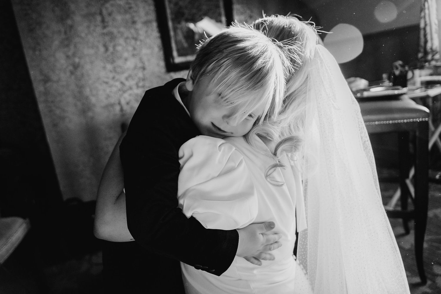 An emotional embrace shared during a touching wedding moment, with a flowing white veil visible in frame. City Hall Dublin Photographer