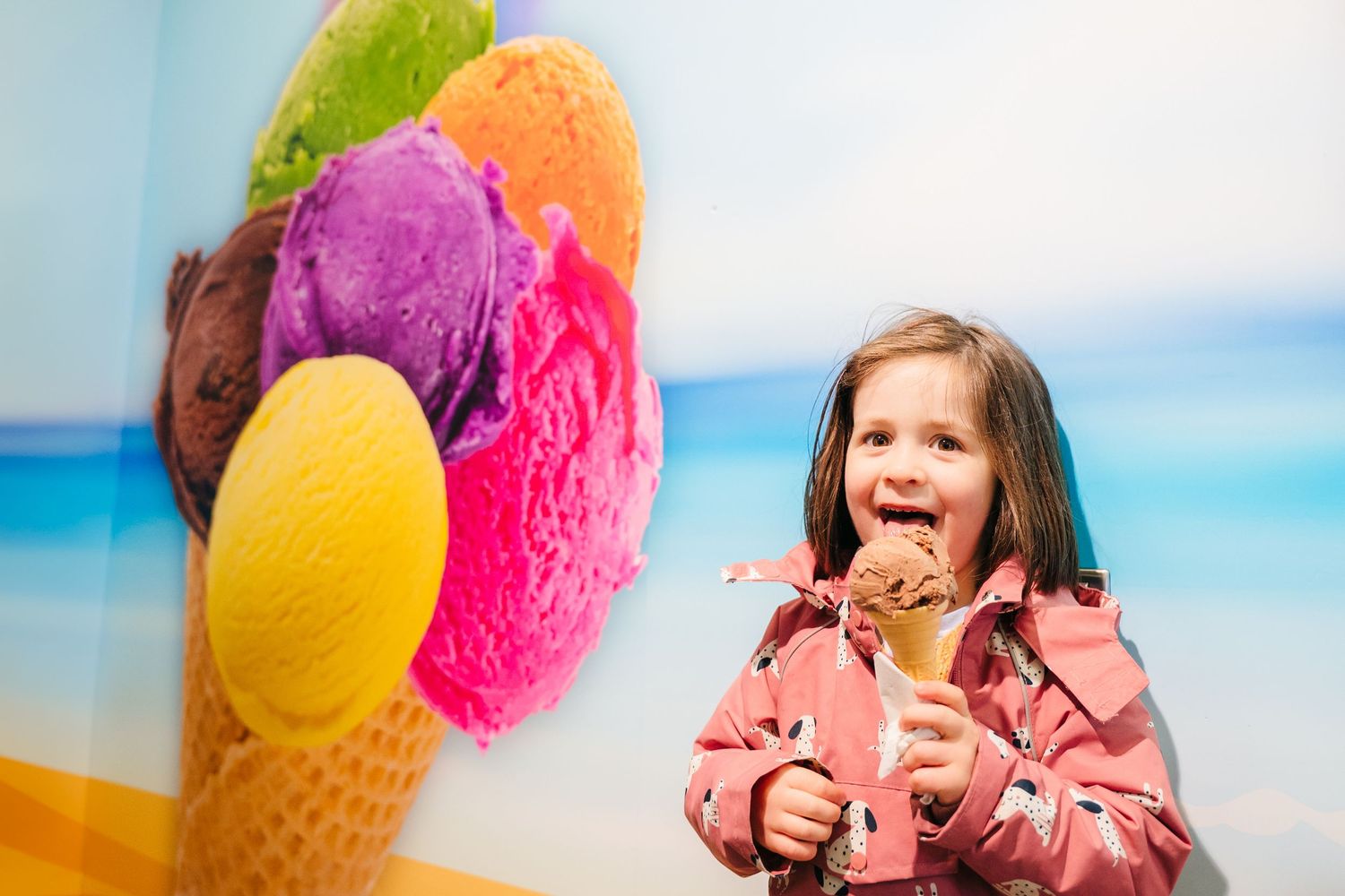 Colorful ice cream cones against a bright blue sky backdrop create a cheerful summer scene. PHOTOGRAPHER Dublin