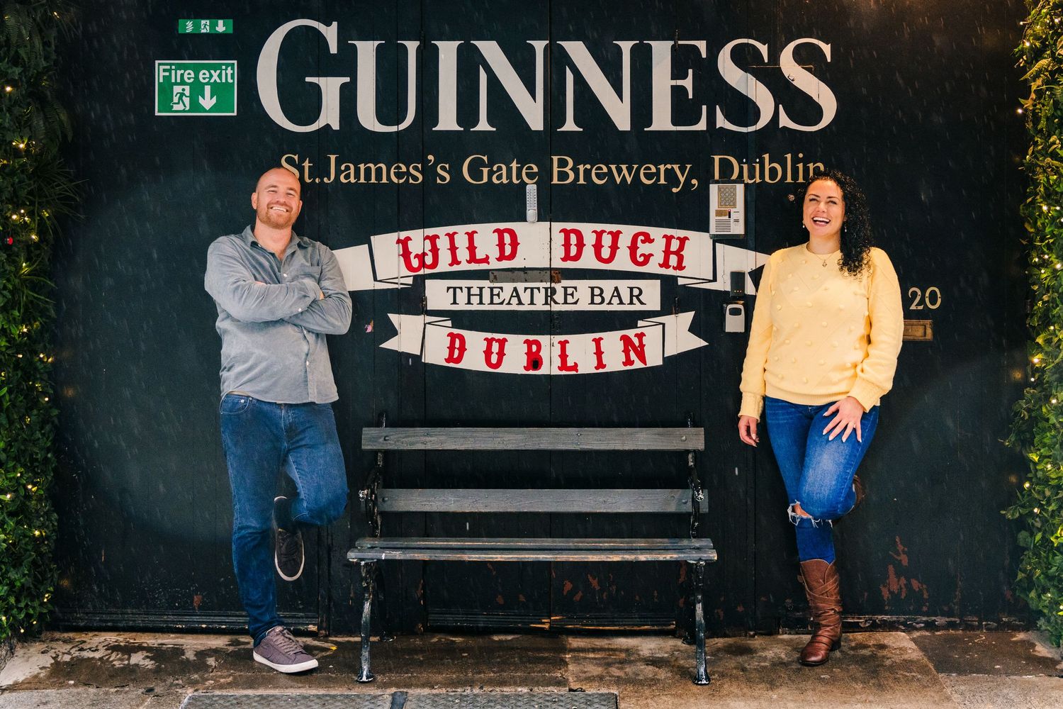 Series of photos showing couple posing in front of Guinness Brewery signs and buildings in Dublin. Proposal Dublin Photographer