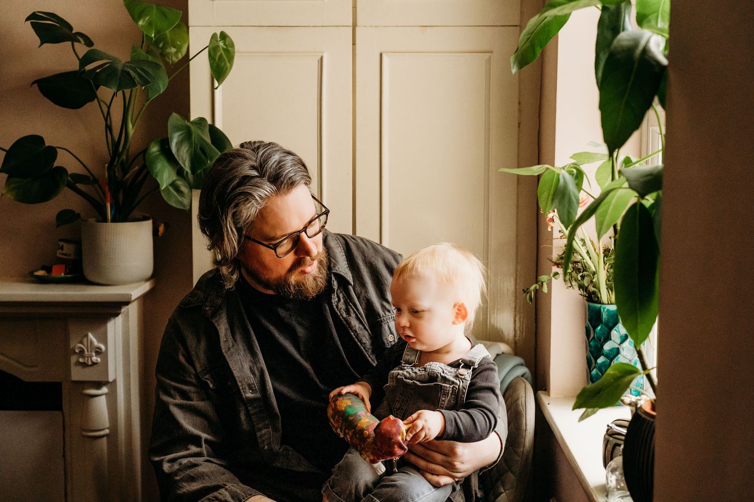 Sunlit interior scene with potted plants and soft natural lighting creating a cozy atmosphere.  Family PHOTOGRAPHER Dublin