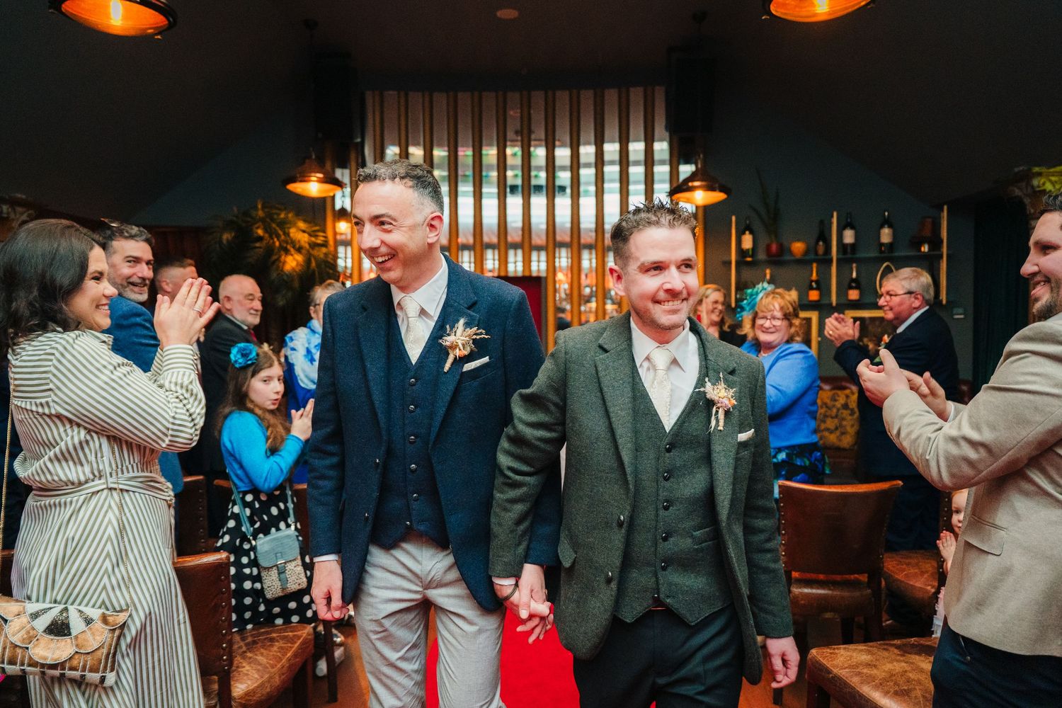 Wedding guests celebrate in a restaurant with wooden panel decorations. Marco Pierre Dublin Wedding Photographer