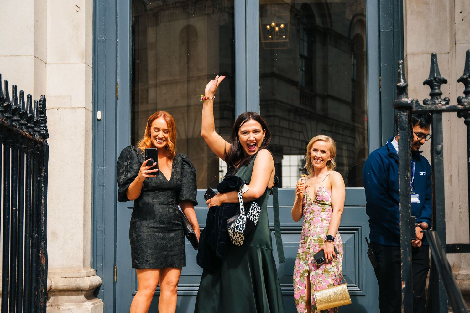 Wedding party posing outside a historic building with blue architectural details.  city hall dublin wedding photos