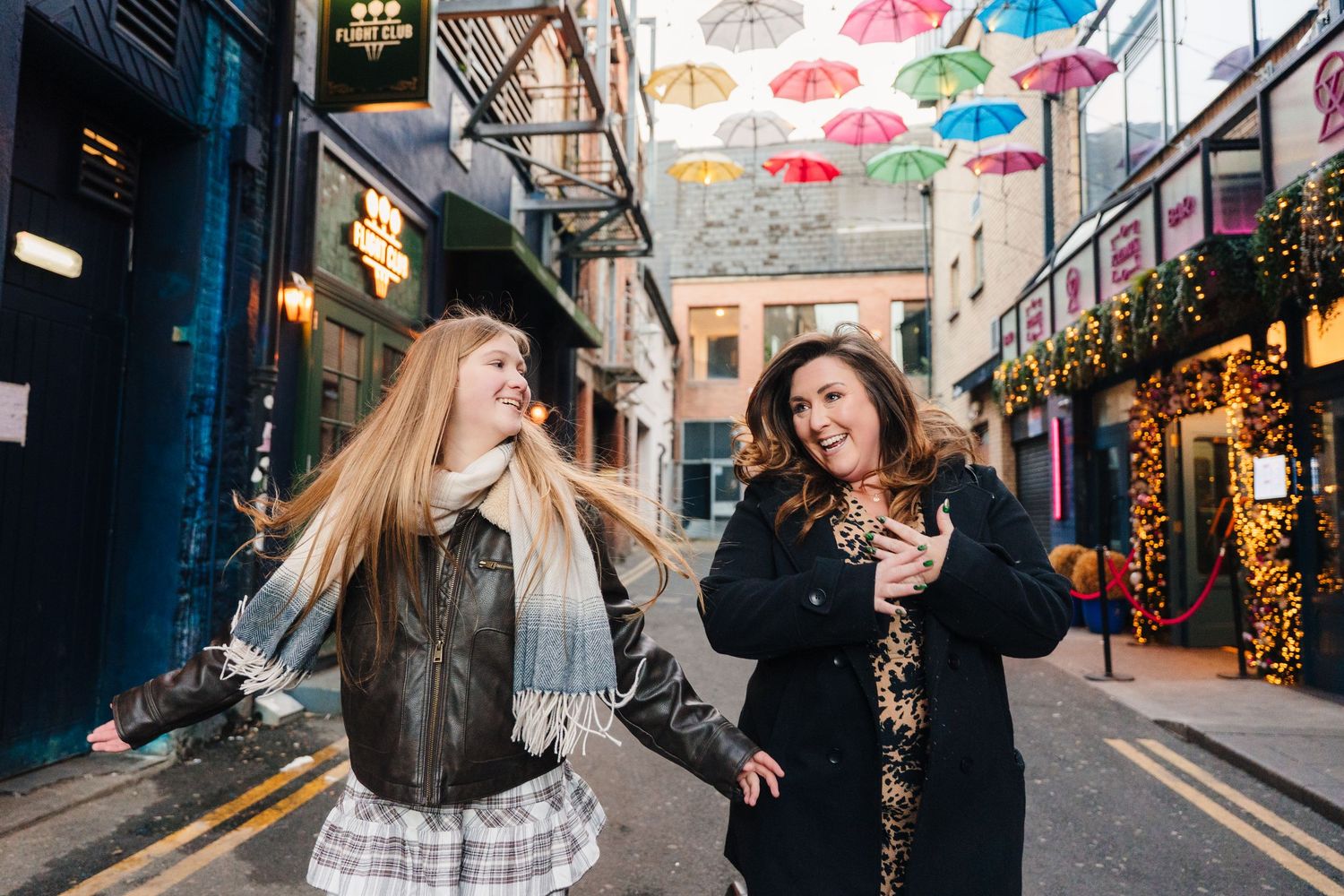 Urban street scene with suspended rainbow umbrellas creating a festive atmosphere. family PHOTOGRAPHER Dublin