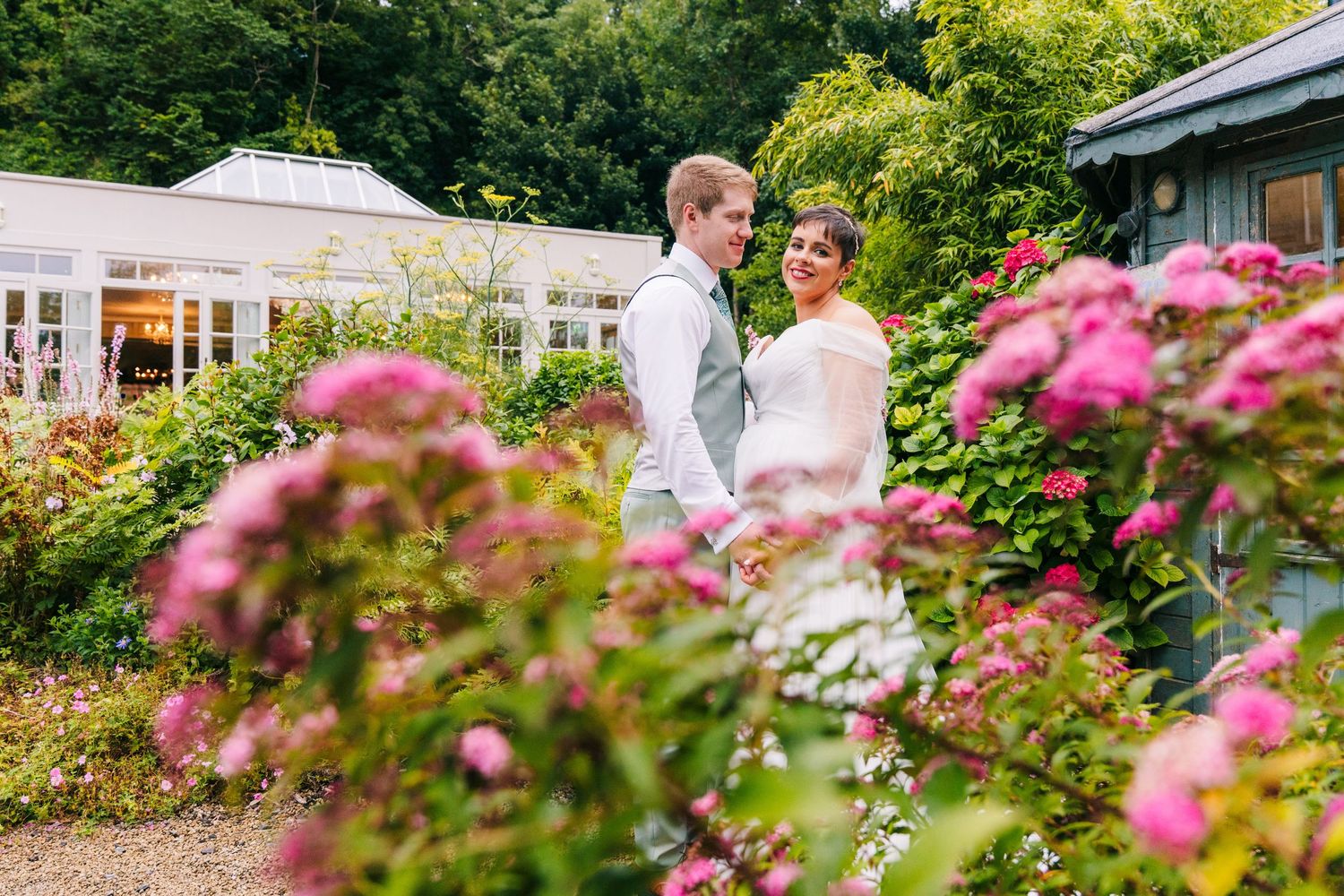 Millhouse slane wedding photographer dublin Garden wedding setting with pink flowers blooming in foreground.