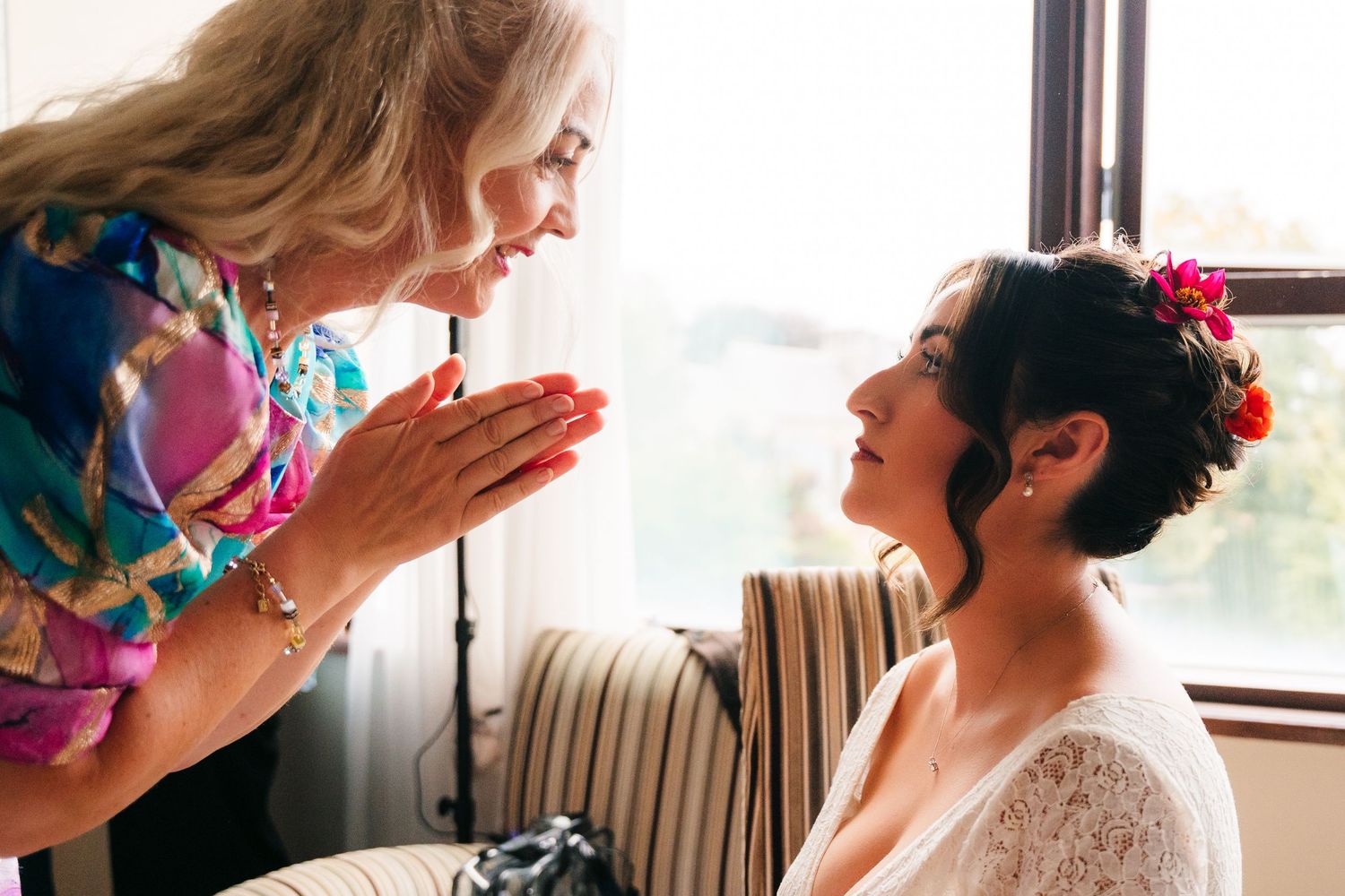 Two people share an emotional moment while getting ready in a bright room by a window. Wedding Photography Trim Castle Ireland