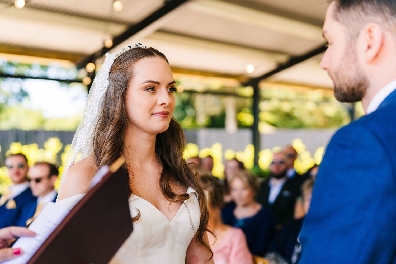 Poulaphouca Wedding photographer wicklow  Outdoor wedding ceremony under covered pavilion with guests in background.