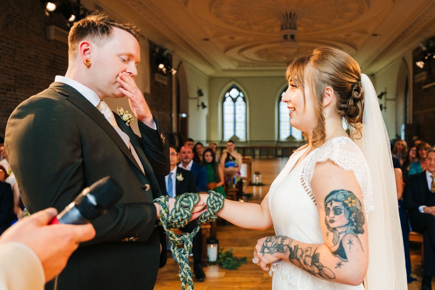 A couple shares an emotional moment during their wedding ceremony in a historic church setting. PHOTOGRAPHER Dublin Ireland Wedding
