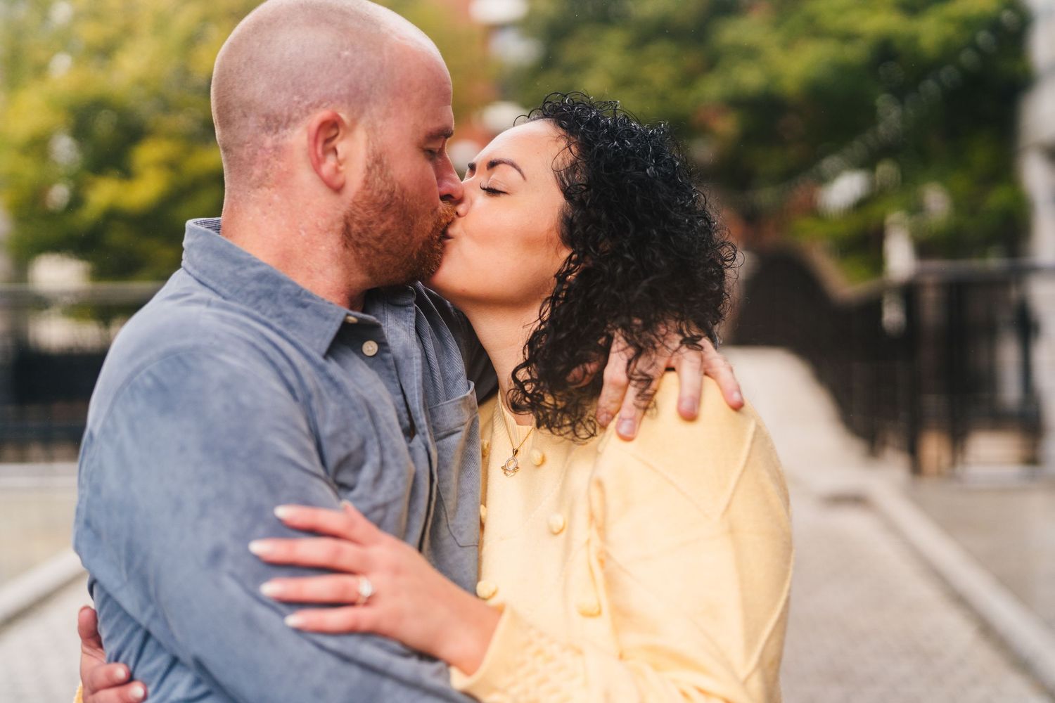 A romantic couple shares tender kisses and embraces outdoors in a series of candid moments. Proposal Dublin Photographer