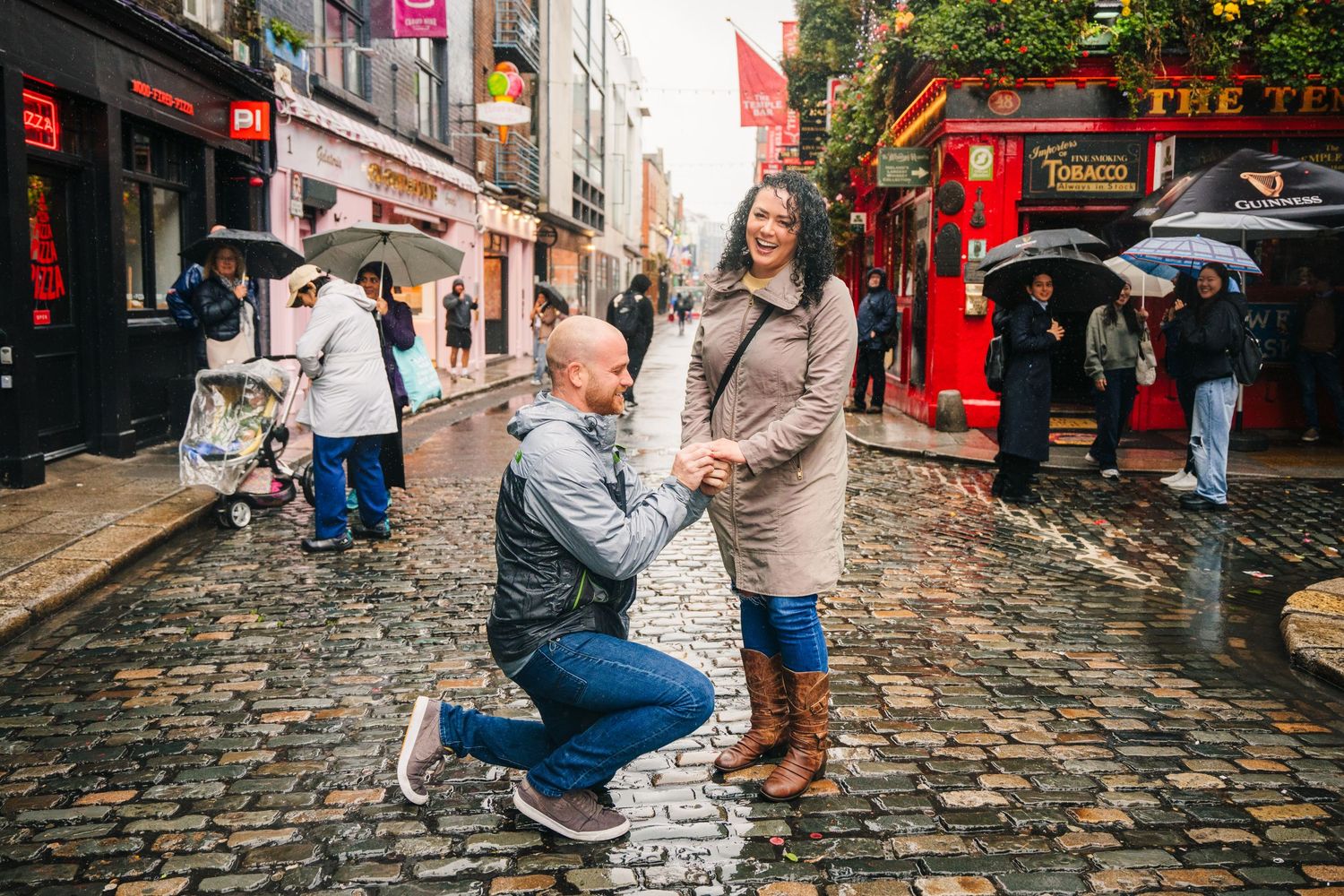 A couple shares a romantic moment on the cobblestone street of Dublin's Temple Bar district Proposal Dublin Photographer