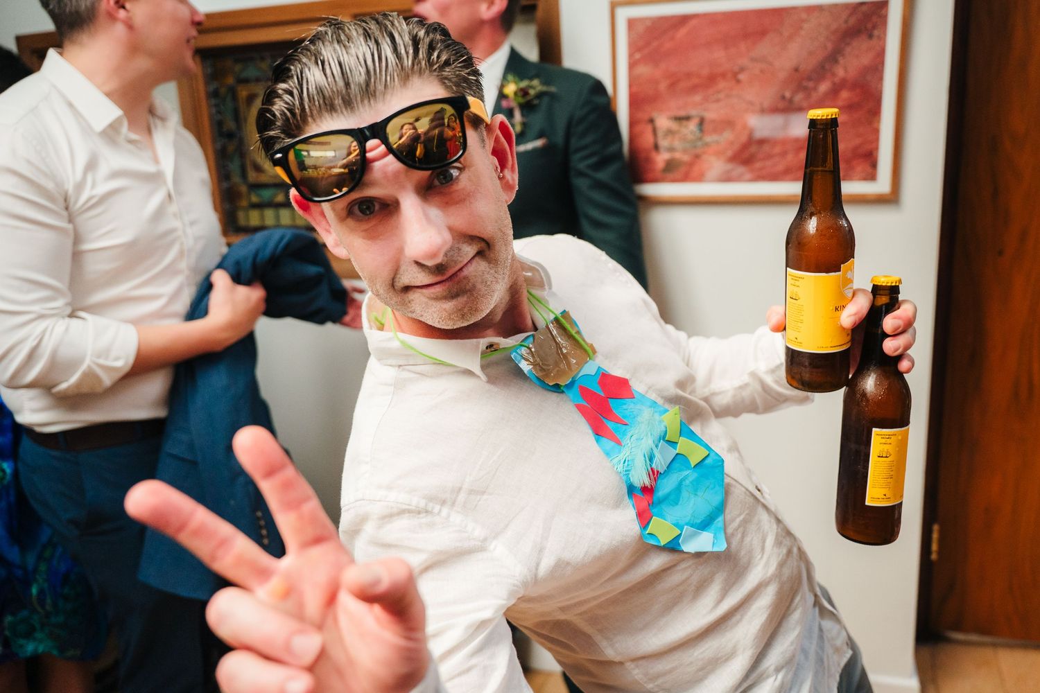 Party guests enjoying drinks and casual moments at an indoor celebration. Same sex wedding PHOTOGRAPHER Dublin