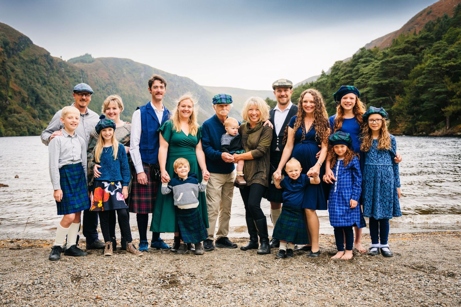 A group of people stand together against a scenic mountain backdrop during an outdoor family gathering. Family photogrAPHER DUBLIN