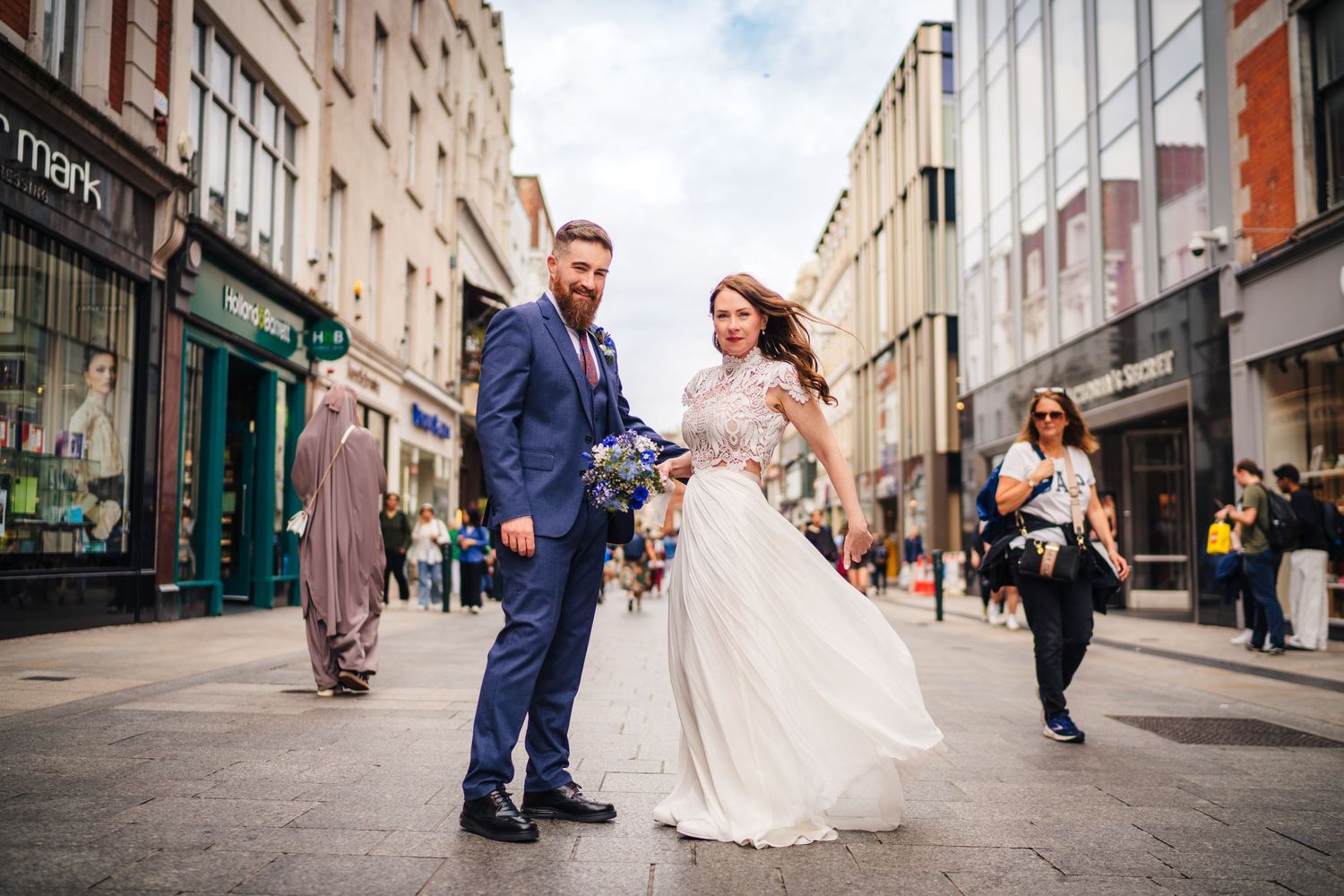 A joyful moment captured of a couple in formal attire dancing on a charming European city street. Wedding PHOTOGRAPHER Dublin