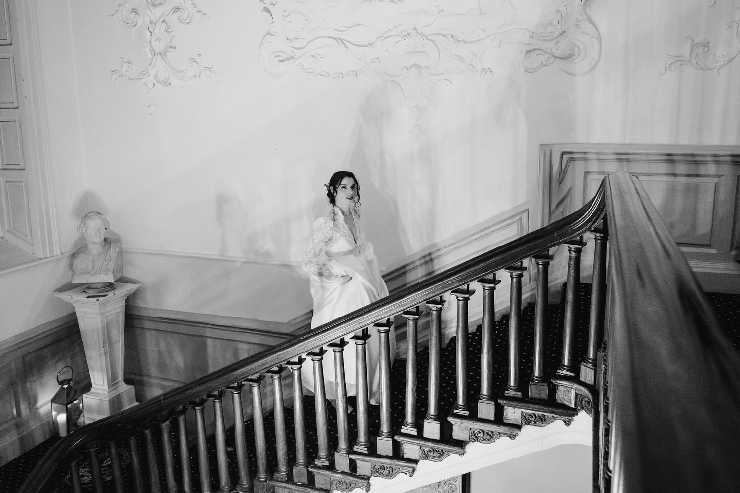 Black and white photo series showing people descending an elegant staircase at formal event. Stephens green club dublin Wedding photographer