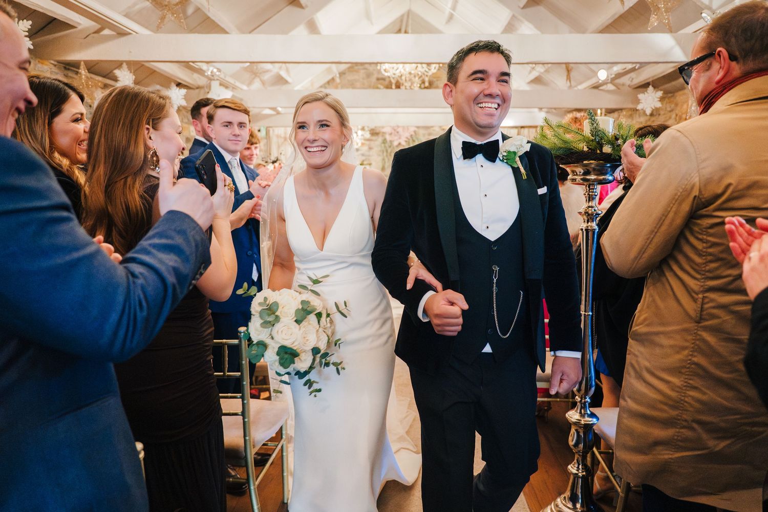 Wedding guests mingle and celebrate during an elegant indoor reception with white decor and string lights Wedding photographer Dublin IRelan