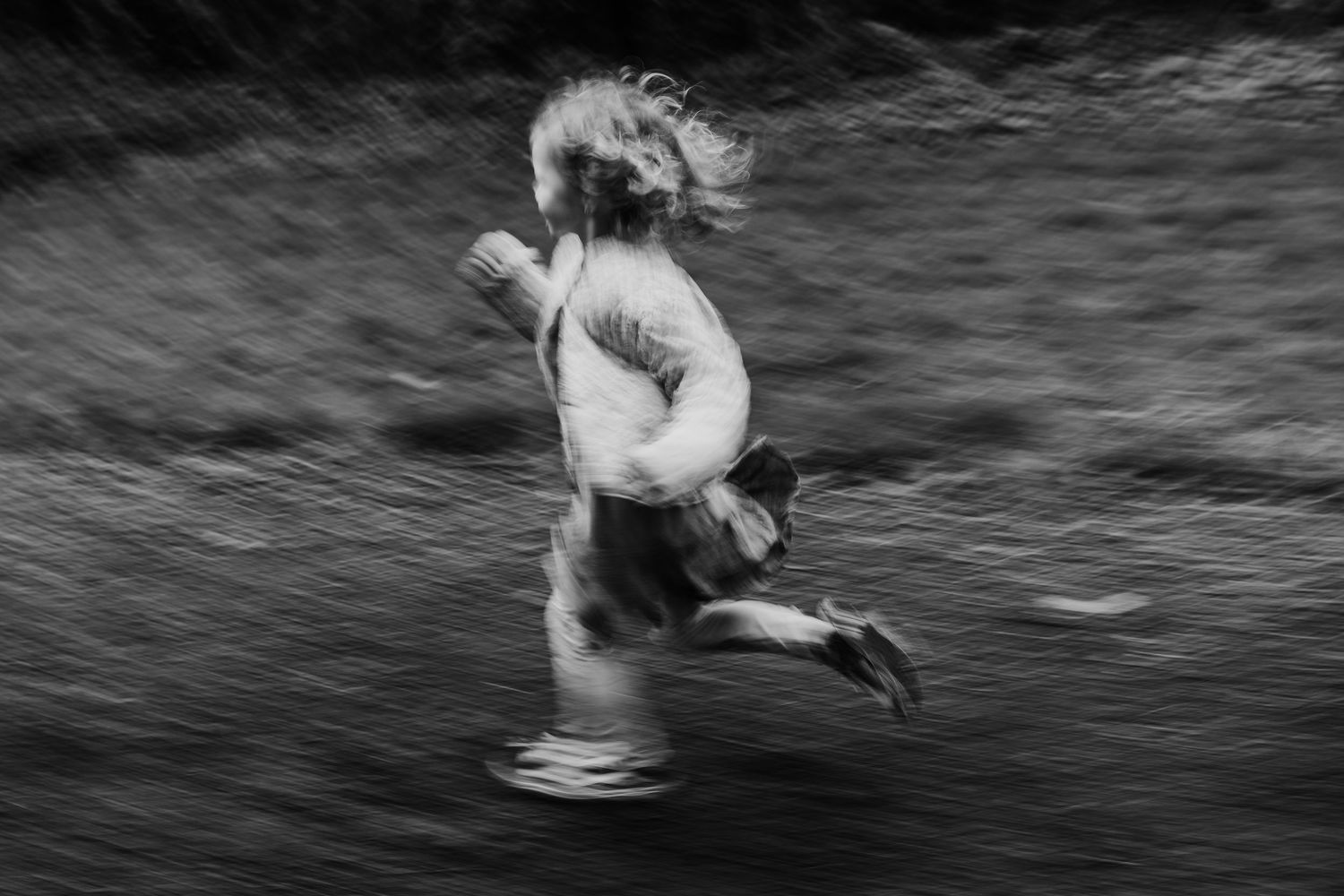 A dynamic black and white capture shows joyful movement through water with motion blur effects. family PHOTOGRAPHER Dublin