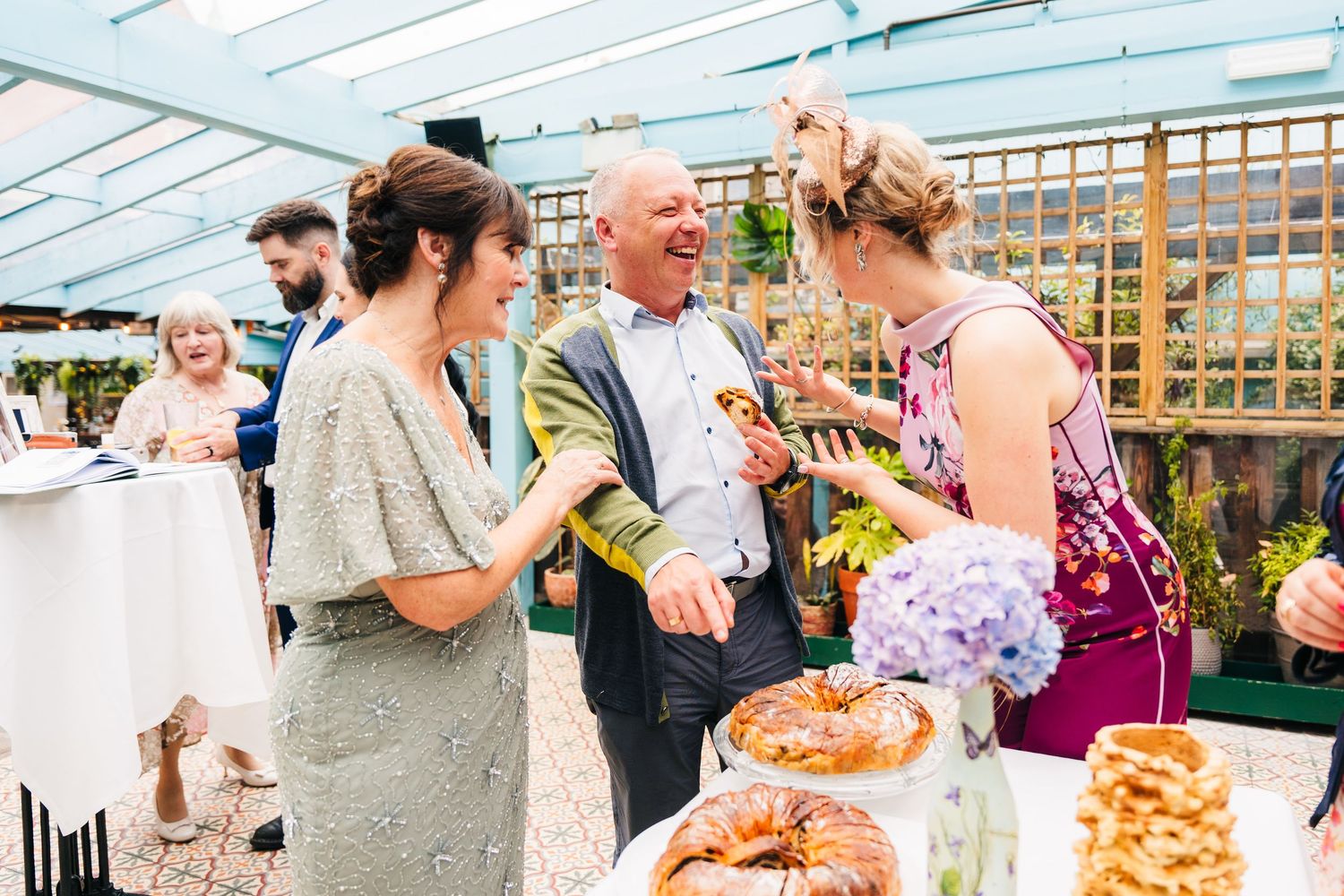 Party guests gather around a buffet table at an outdoor covered venue. House Dublin Wedding Photographer