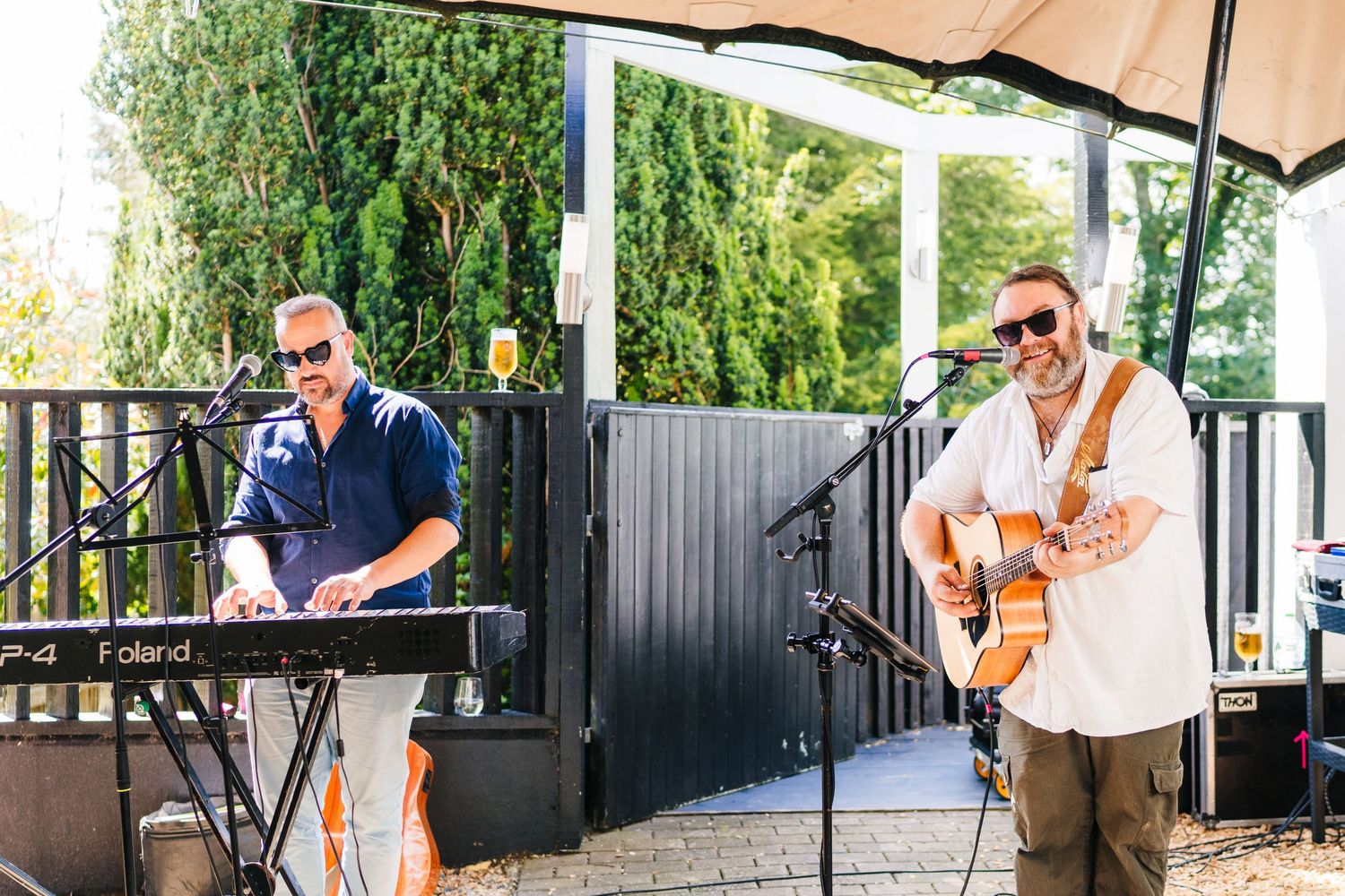 Poulaphouca Wedding photographer wicklow  Two musicians perform at an outdoor wedding with keyboard and acoustic guitar.
