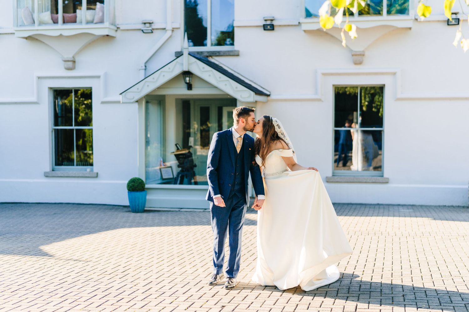 Poulaphouca Wedding photographer wicklow  Couple walking together outside white building with classic architecture.