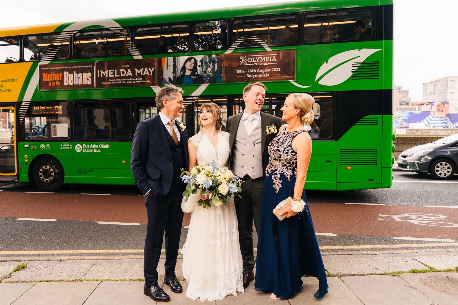 Wedding party poses in front of a bright green double-decker bus on their special day. PHOTOGRAPHER Dublin Ireland Wedding