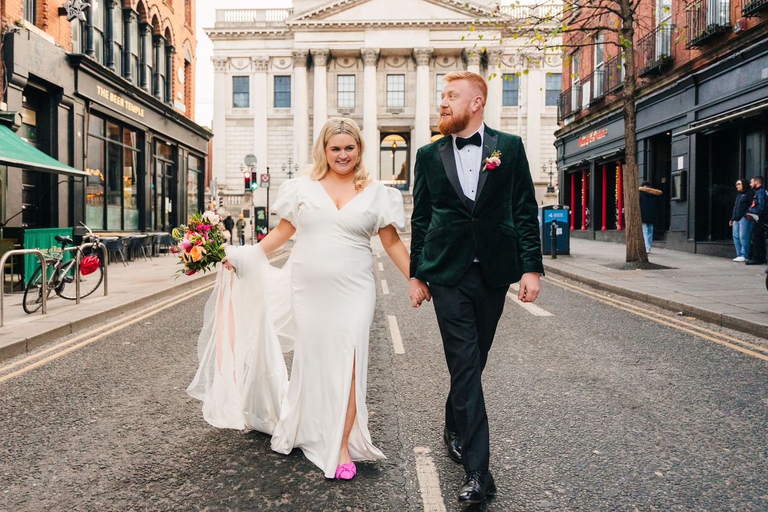 Wedding party walking down a city street with classic architecture in the background. City Hall Dublin Photographer
