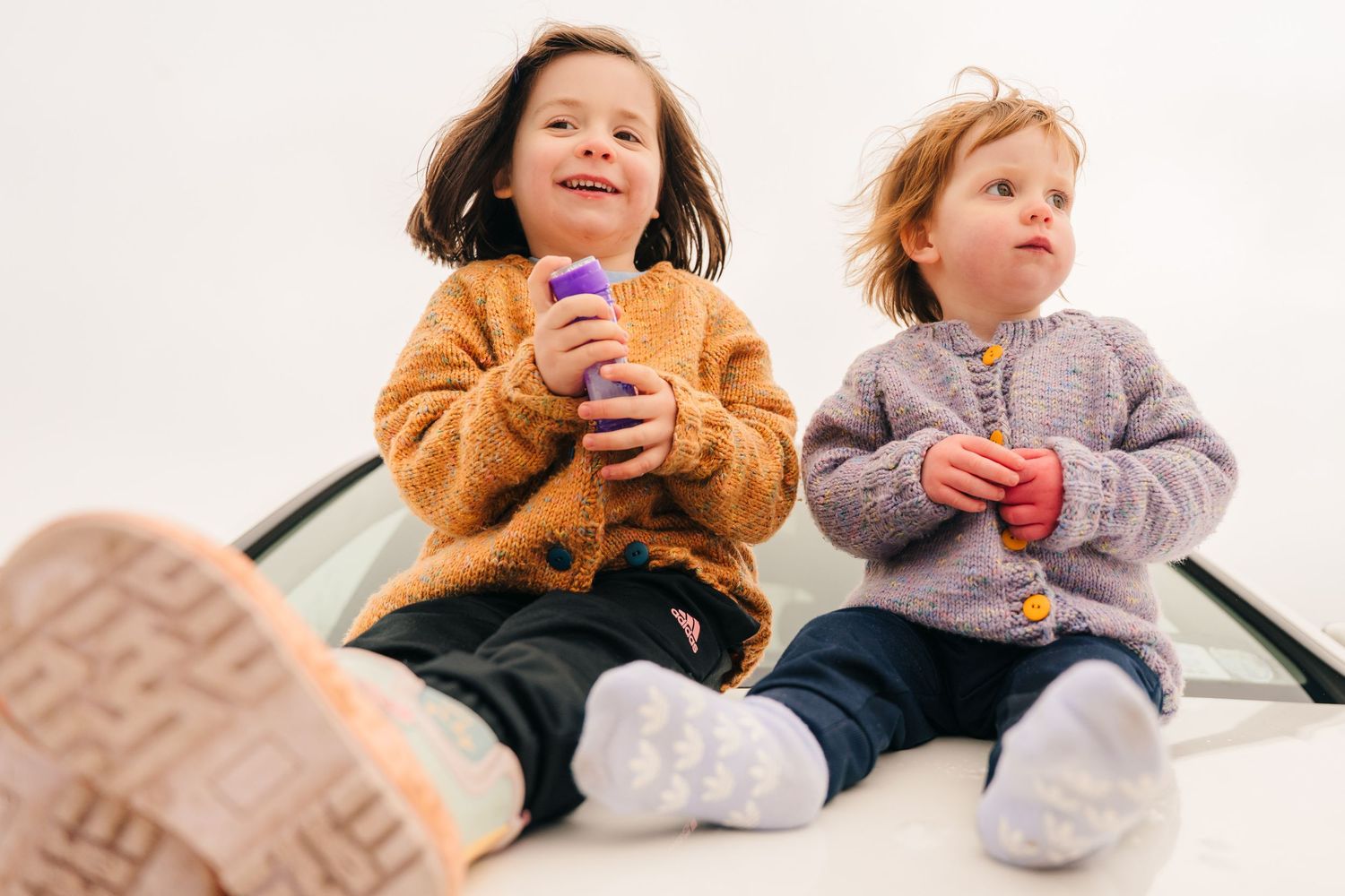 Two kids sitting together holding colorful drinks and smiling. PHOTOGRAPHER Dublin