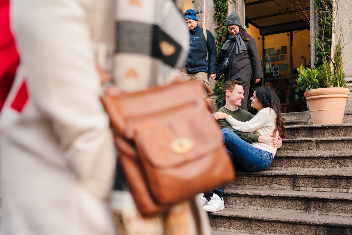 Couple walking together on city steps with shops and cafes in the background. Surprise proposal dublin photography