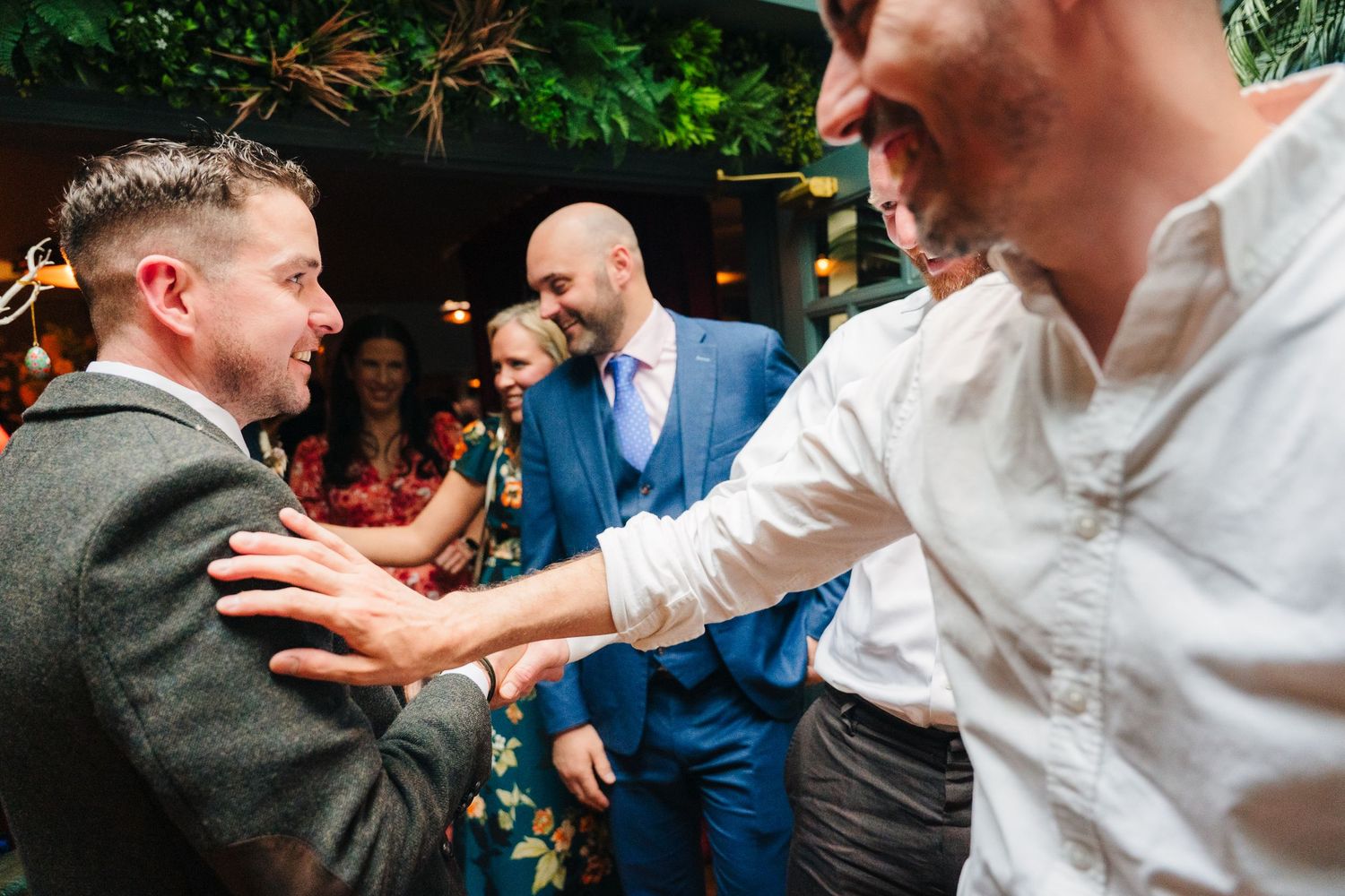 Energetic dancing and celebration at an outdoor wedding reception under greenery. Marco Pierre Dublin Wedding Photographer