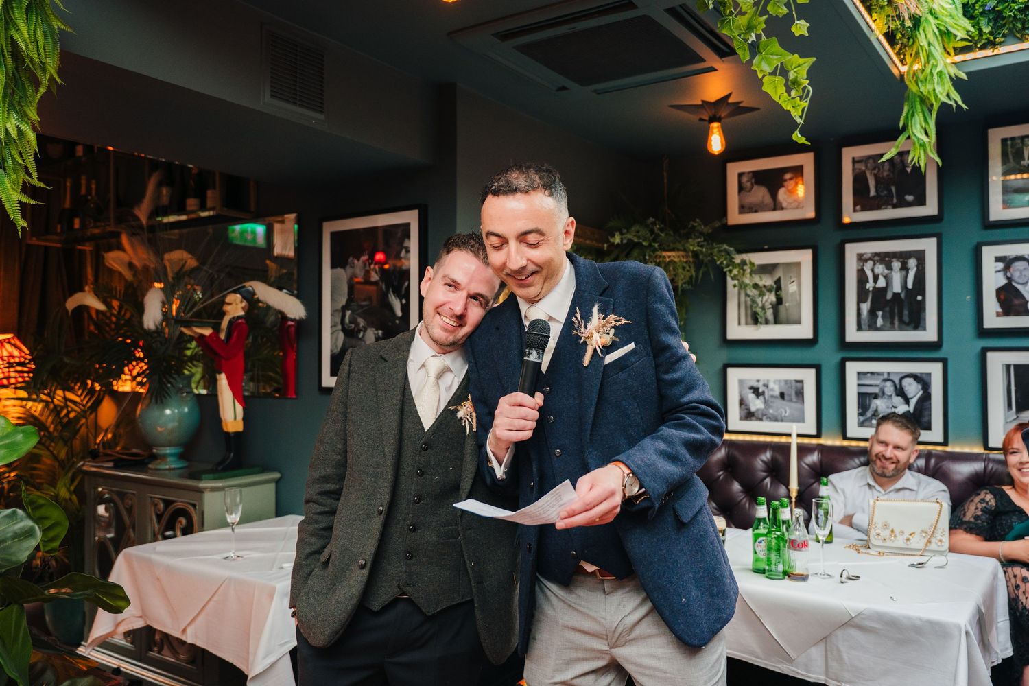 Two people sharing a laugh while reading speeches at a restaurant reception. Marco Pierre Dublin Wedding Photographer
