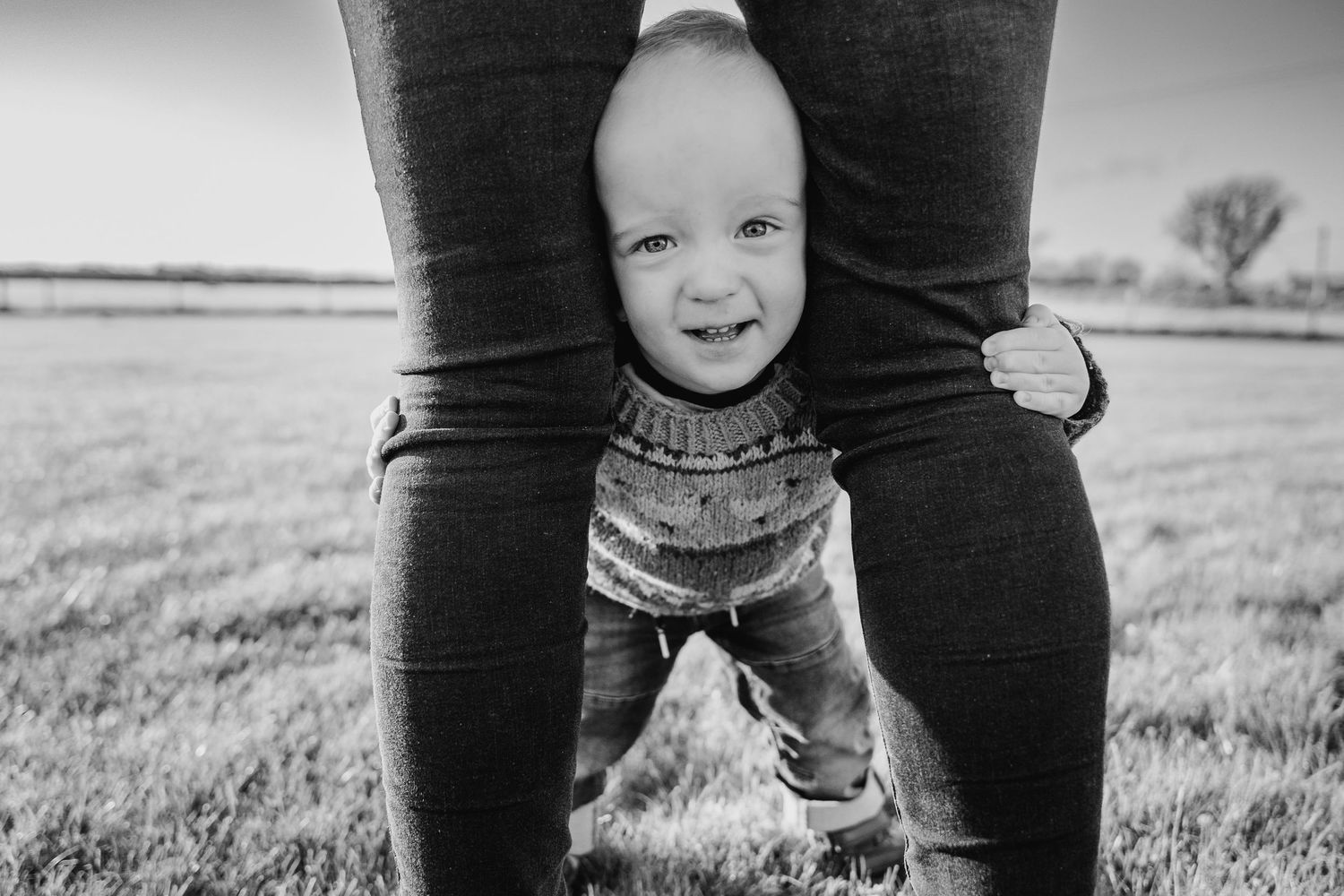 Parent and child's feet in cowboy boots stand in black and white against a rustic outdoor backdrop. family PHOTOGRAPHER Dublin
