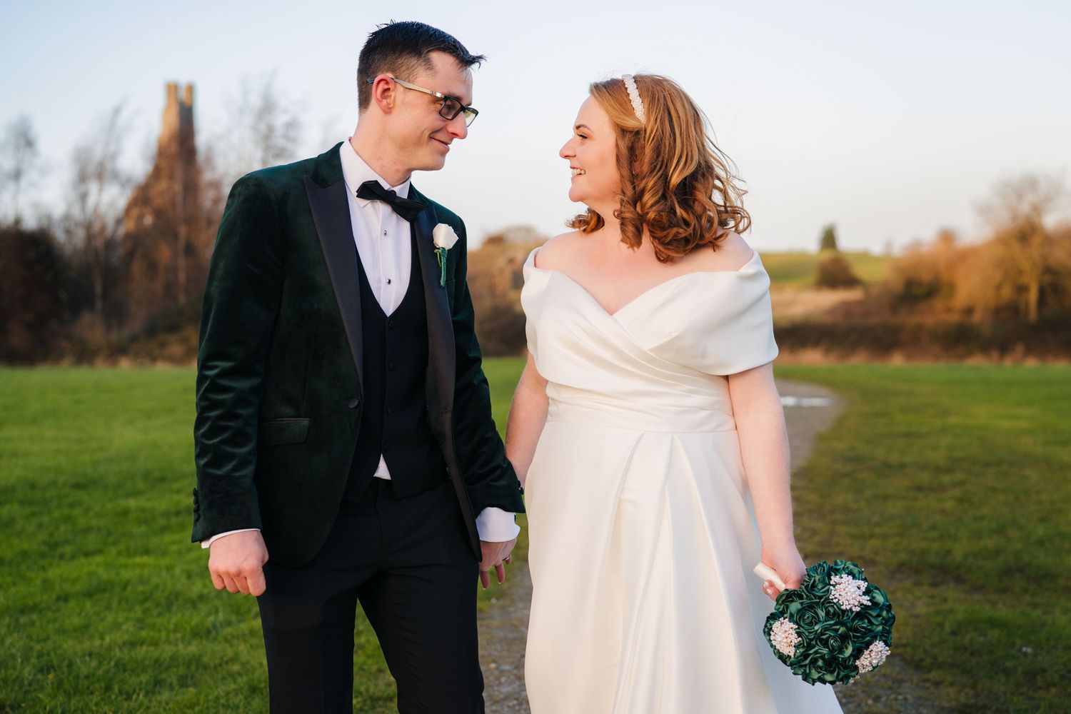 A couple shares romantic moments in a sunny outdoor setting during their wedding celebration.  Wedding PHOTOGRAPHER Trim Castle
