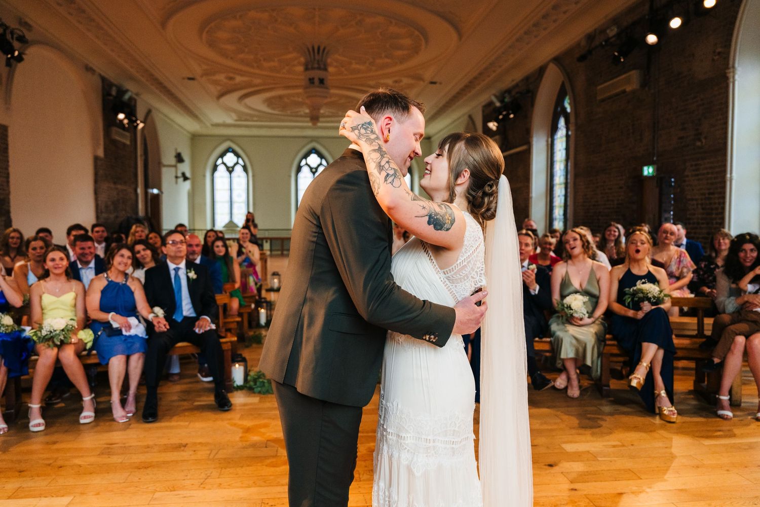 Newlyweds sharing their first kiss during wedding ceremony with guests watching. PHOTOGRAPHER Dublin Ireland Wedding