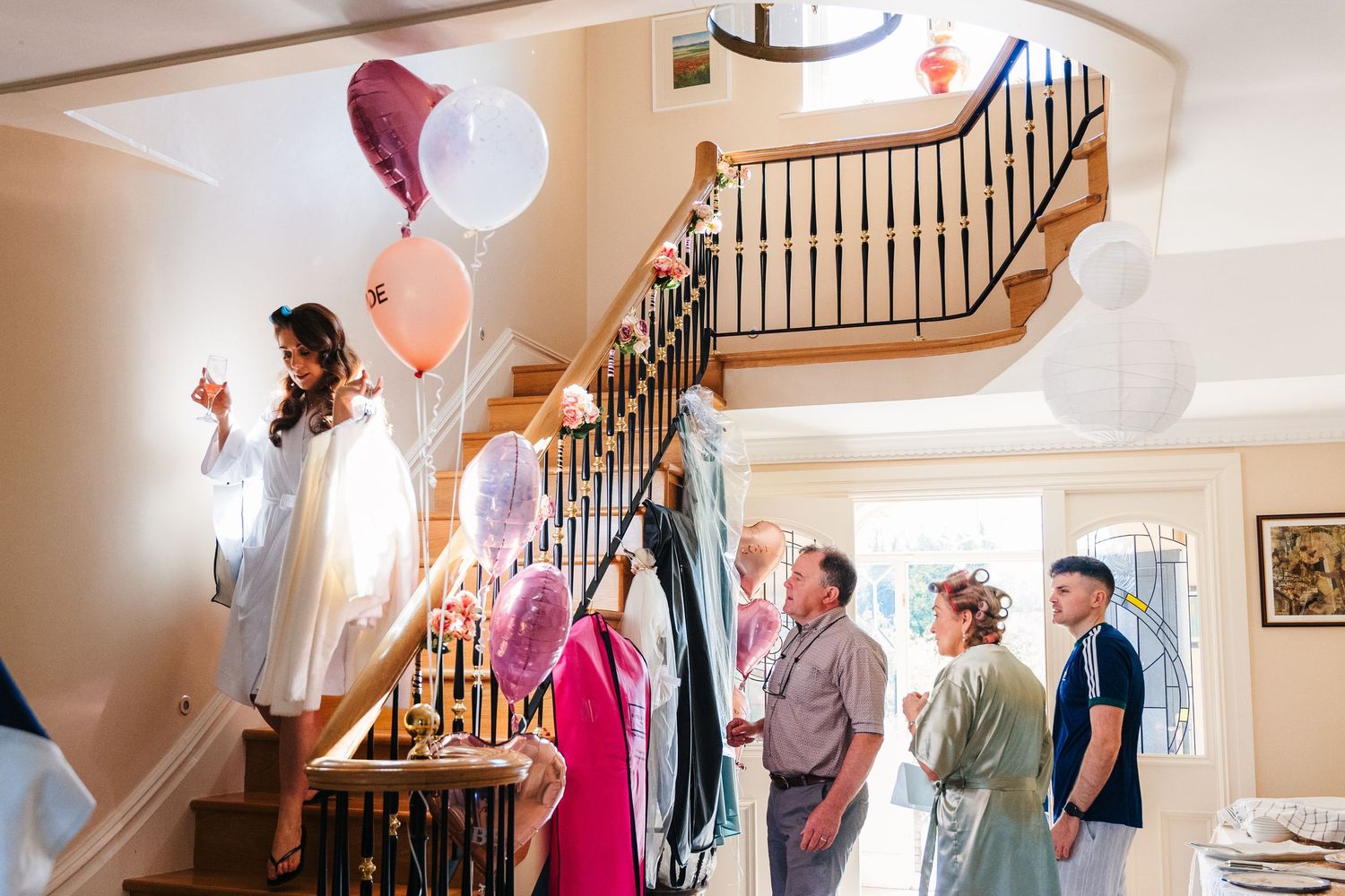 Castle Leslie Wedding Photographer Dublin People celebrating at a wedding venue with balloons and decorative staircase as backdrop.