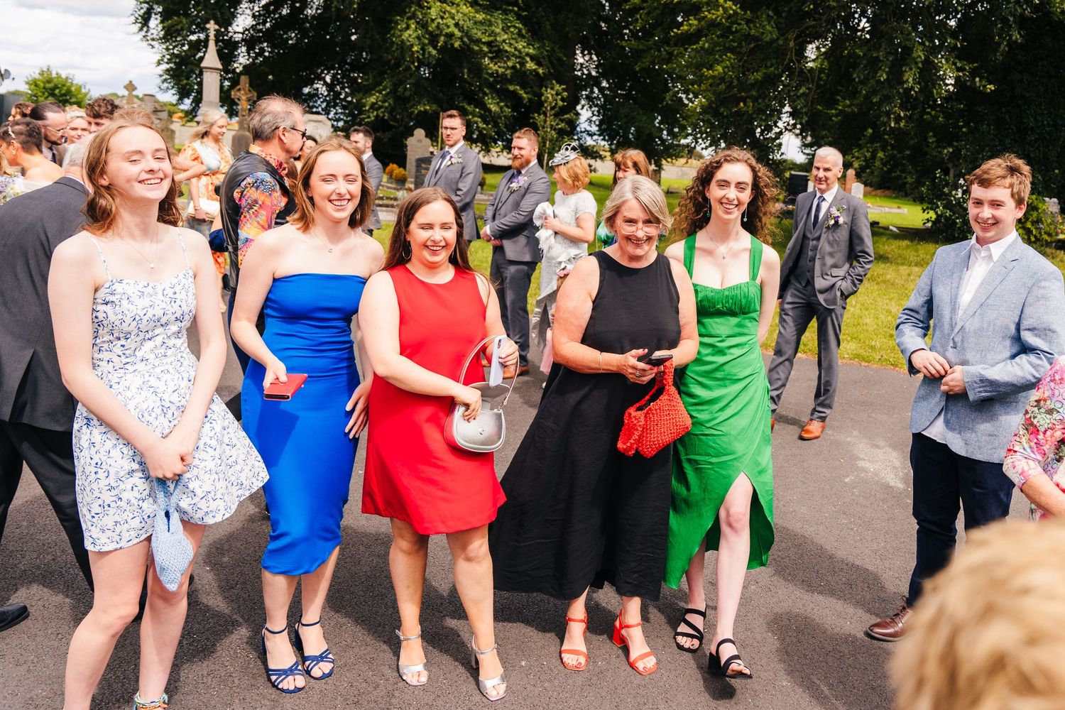 Millhouse slane wedding photographer dublin Large group of wedding guests gather outdoors on a summer day for a joyful celebration.