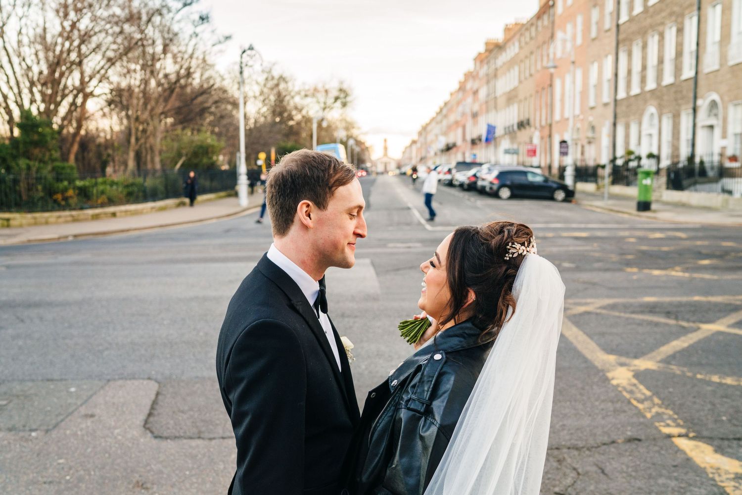 A couple share an intimate moment on a street lined with Georgian buildings at sunset. Wedding PHOTOGRAPHER Dublin