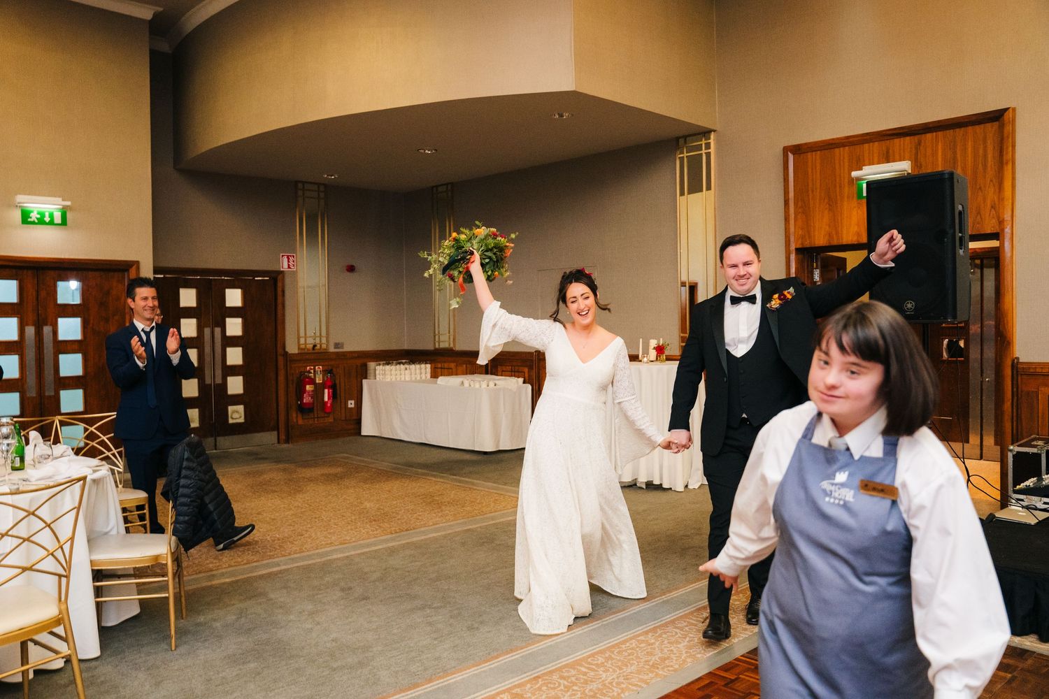 Wedding guests dancing together in a spacious reception hall with warm lighting.Wedding Photography Trim Castle Ireland