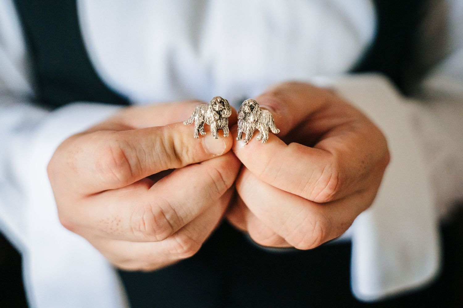 Close-up shot of hands holding two ornate wedding rings with diamond details. LGBTQ Ashley Park Wedding Photographer