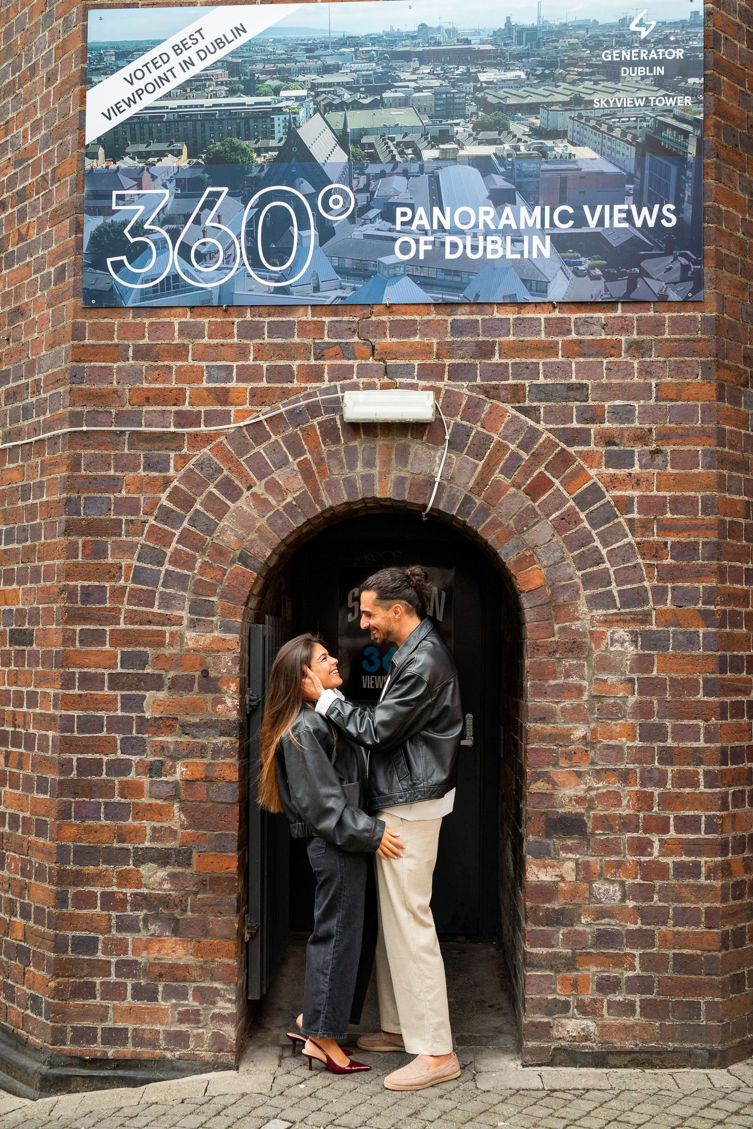 Romantic scene under brick archways showcasing panoramic Dublin city views. Couple's Photoshoot PHOTOGRAPHER Dublin