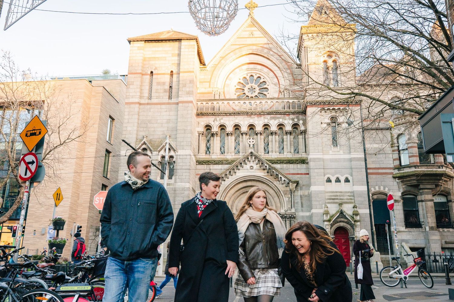 People walking outside a historic church building on a winter afternoon. family PHOTOGRAPHER Dublin