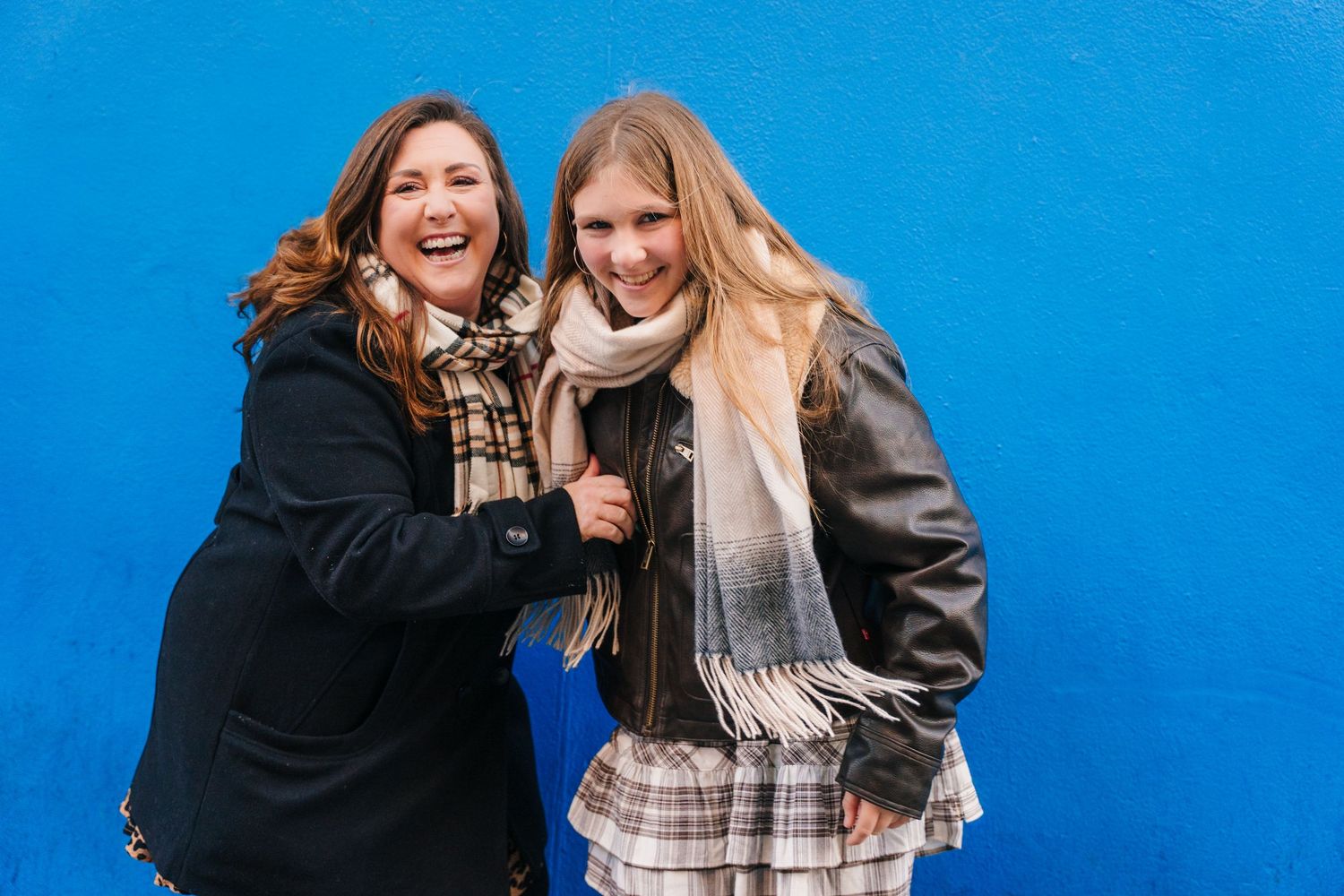 Group of friends laughing and posing against a vibrant blue wall background. Family walking through Dublin city centre during a relaxed vaca