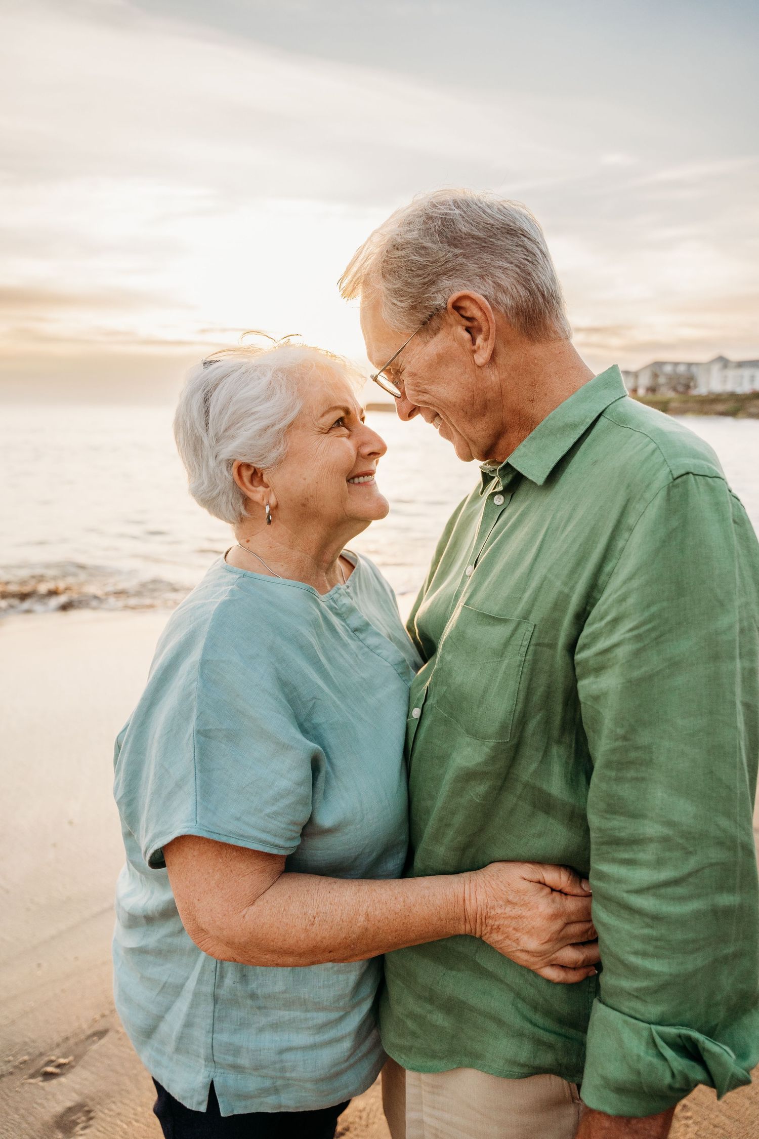 Elderly couple sharing intimate moments and laughter while embracing on a beach at sunset. PHOTOGRAPHER Dublin ireland