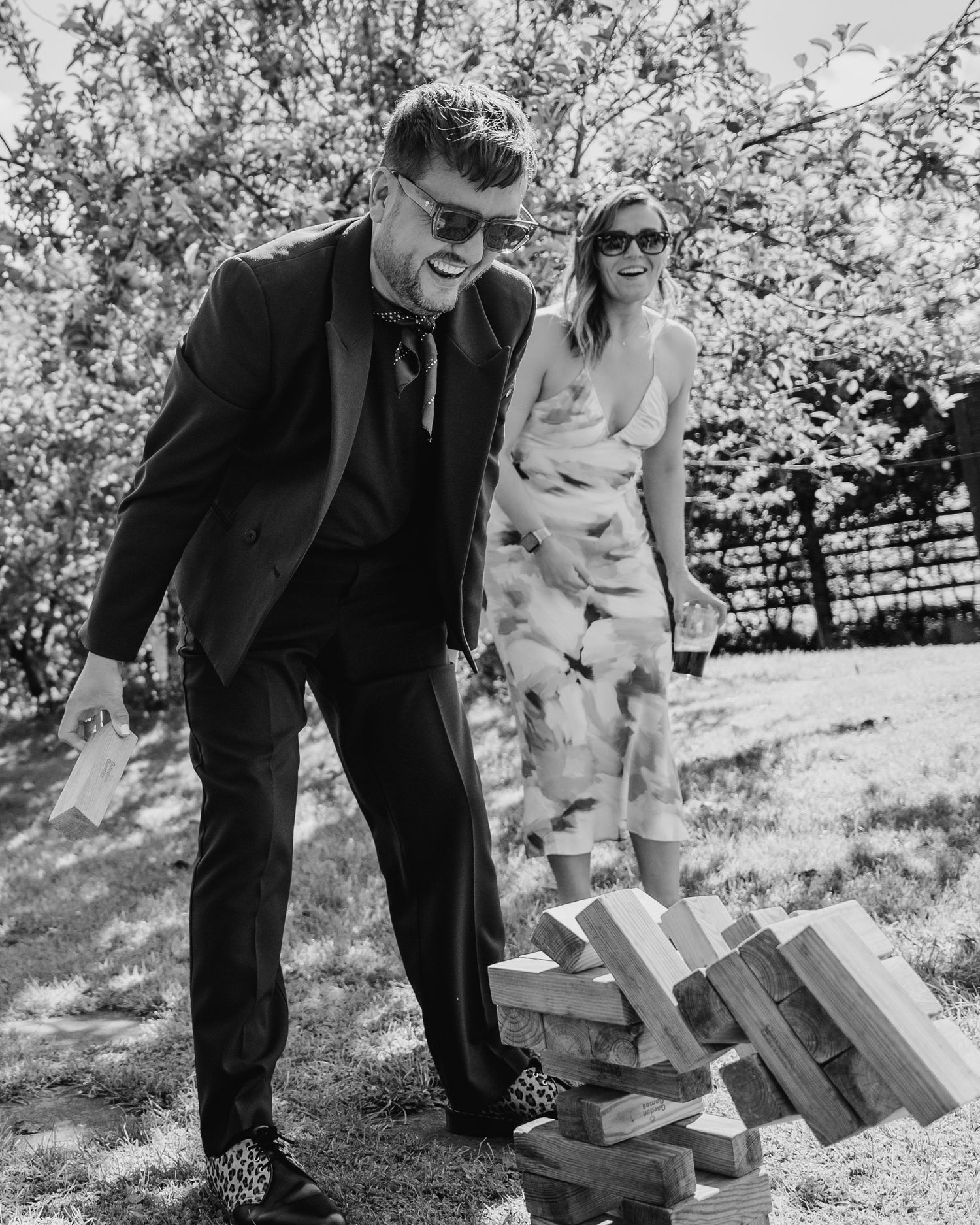 Black and white photo of couple playing giant Jenga game at outdoor event. . Village Barn Tyrrellspass wedding photographer Ireland