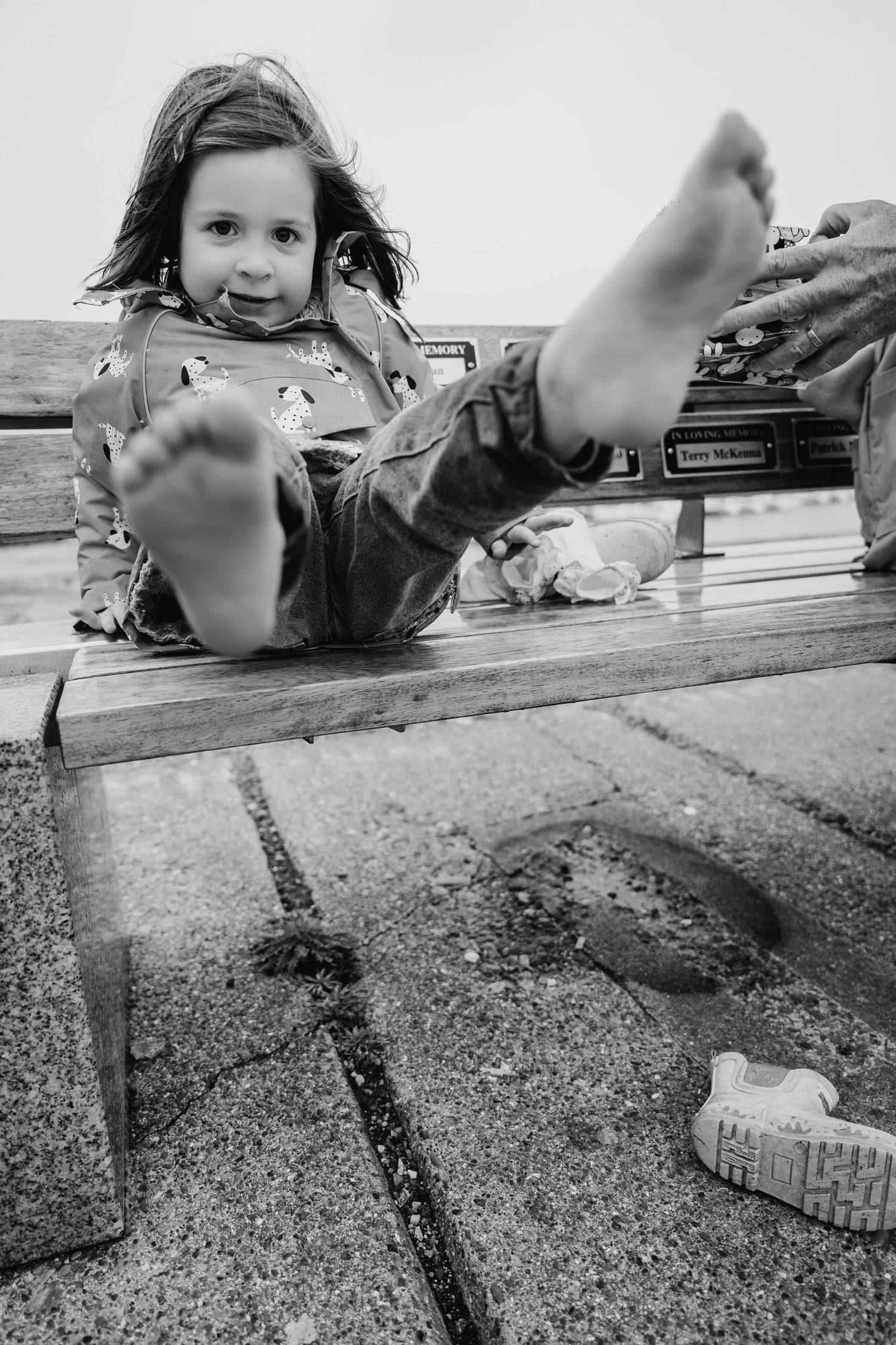 A playful black and white photo showing bare feet on a wooden deck. PHOTOGRAPHER Dublin