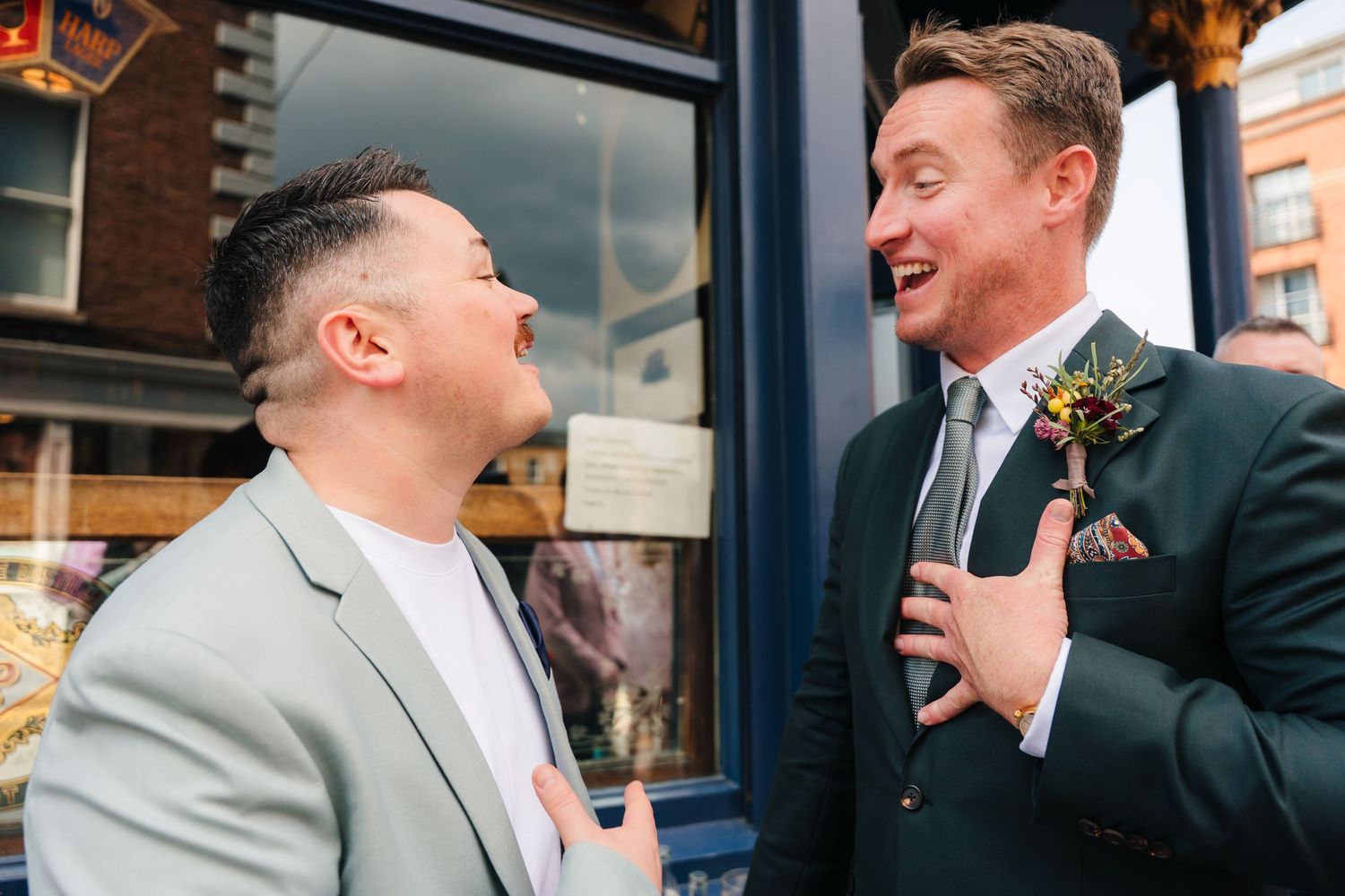 Guests share joyous moments and laughter during a wedding celebration outside a venue. Same sex wedding PHOTOGRAPHER Dublin