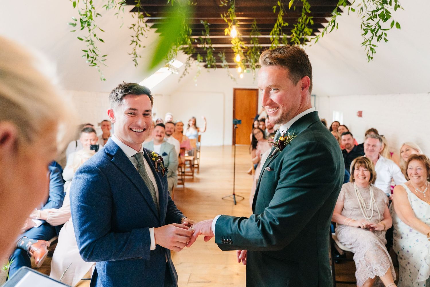 Wedding celebration in a rustic venue with exposed brick walls and hanging plants. Same sex wedding PHOTOGRAPHER Dublin
