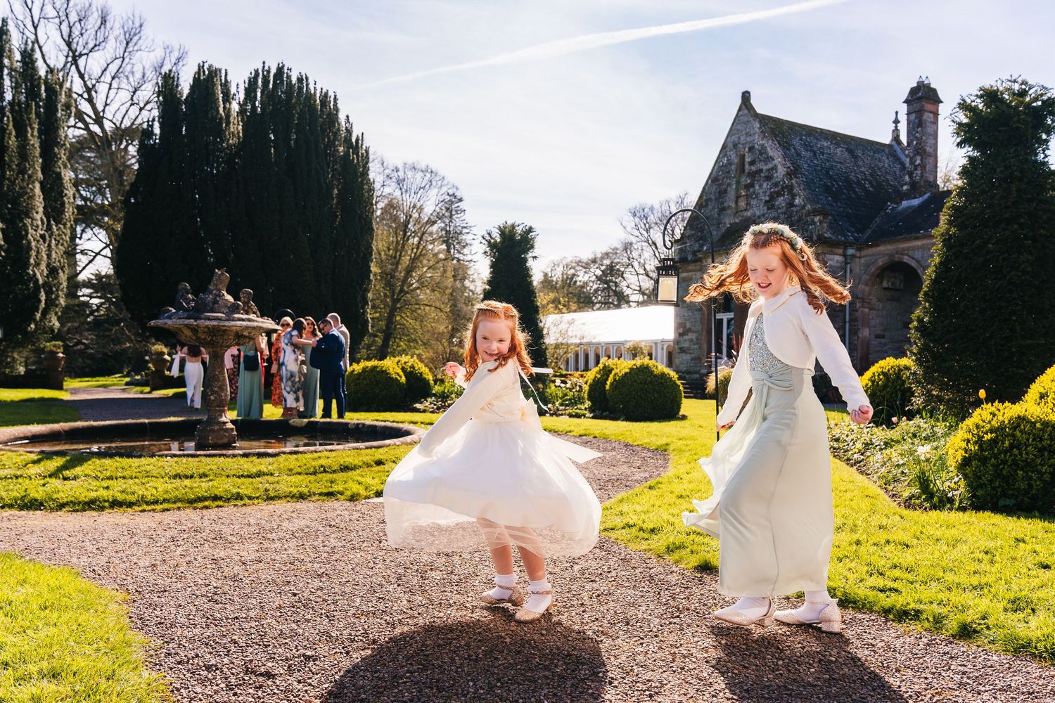 Castle Leslie Wedding Photographer Dublin Wedding party walking through scenic garden path on sunny afternoon.