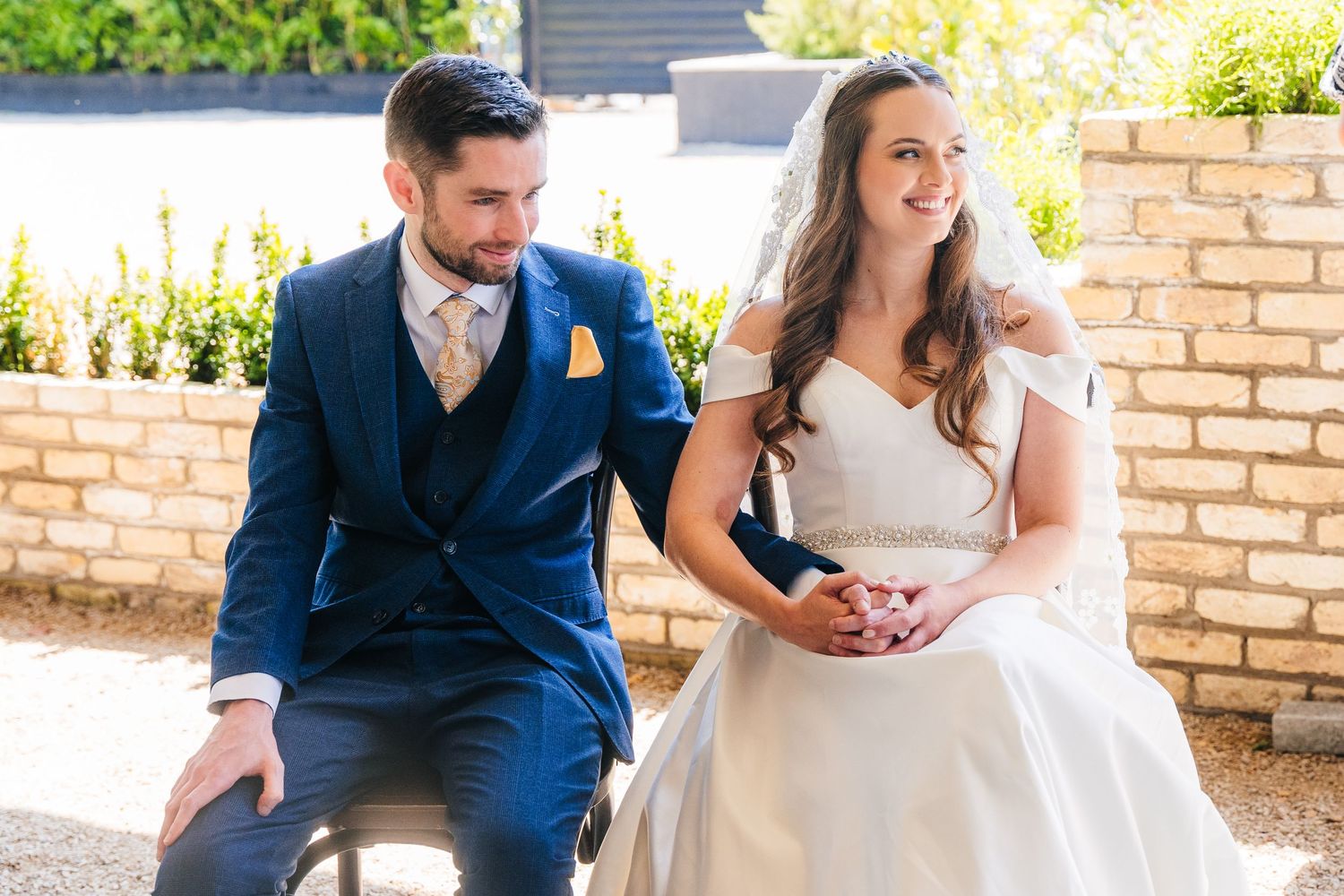 Poulaphouca Wedding photographer wicklow  Wedding party members sharing a candid moment on brick patio steps.