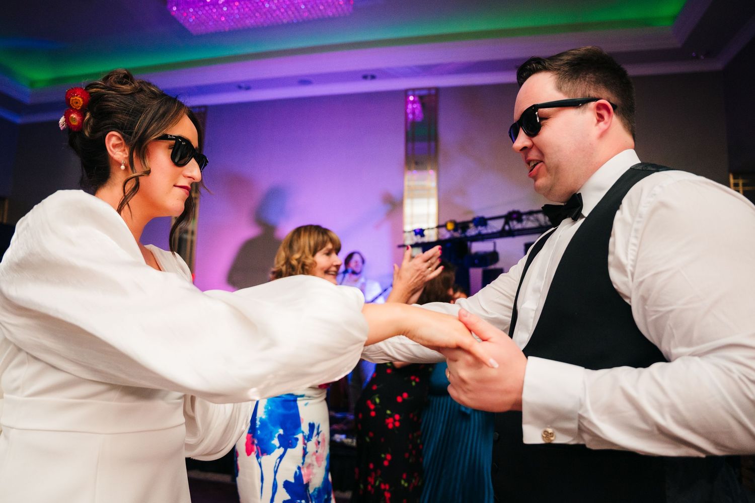Wedding guests dancing energetically under purple and blue party lights at reception.Wedding Photography Trim Castle Ireland