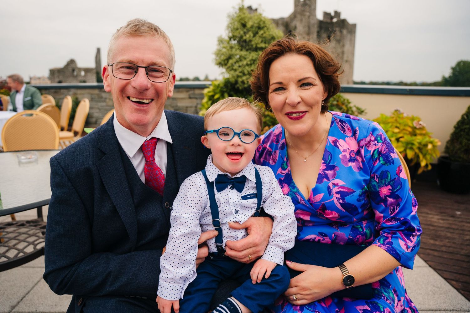 Wedding guests sitting together and sharing joyful moments during outdoor celebration.Wedding Photography Trim Castle Ireland
