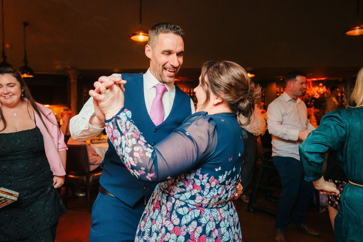 Wedding reception dance party with guests enjoying themselves under warm lighting. Marco Pierre Dublin Wedding Photographer