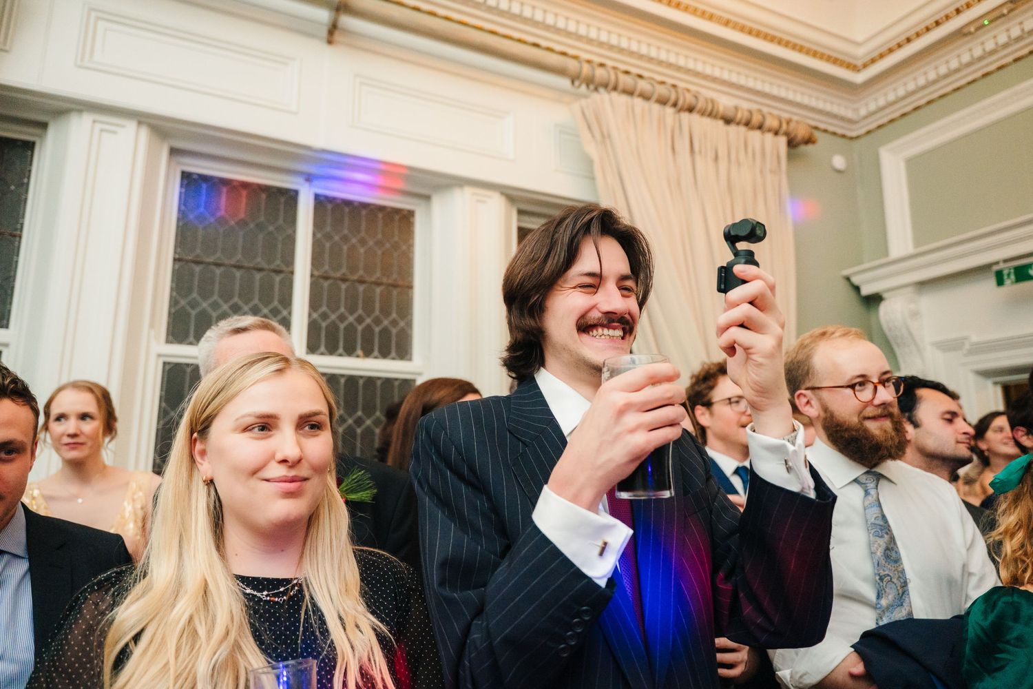Wedding reception guests dance and celebrate in an elegant room with ornate moldings. Stephens green club dublin Wedding photographer